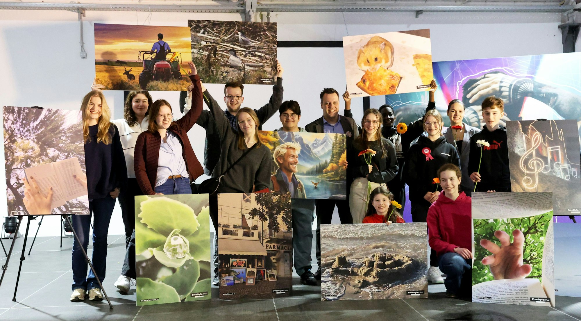 Die Teilnehmer des Projekts "Freestyle Euskirchen" halten ihre Fotografien in die Luft.