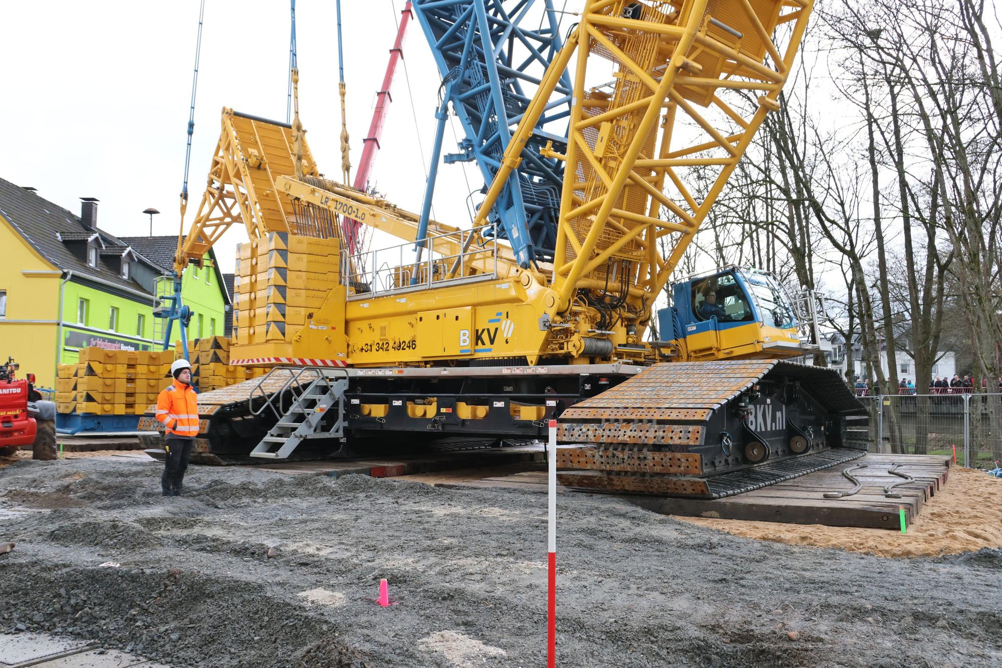 Ein hausgroßer Kran steht auf einer Baustelle.