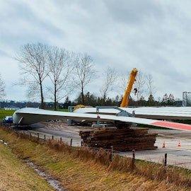 Rotorblätter lagern auf einer Wiese.