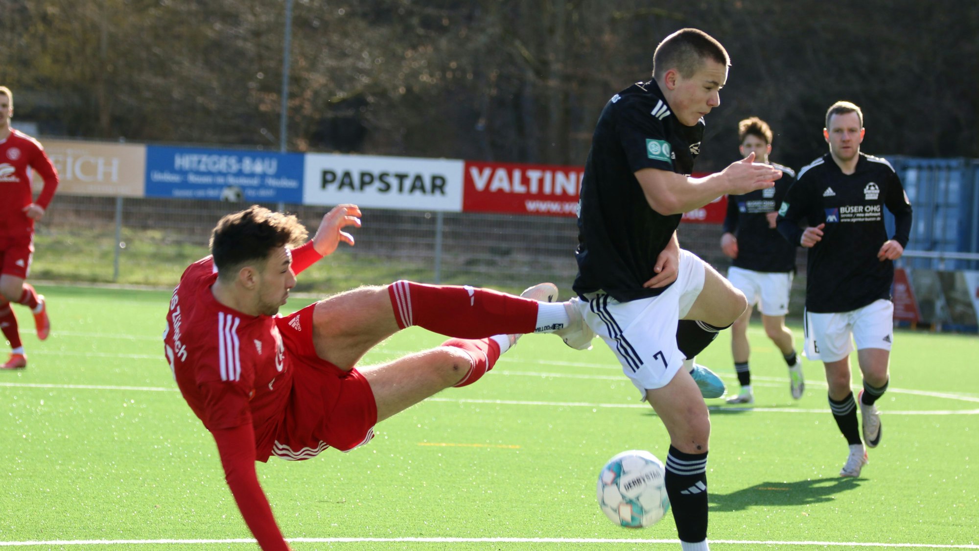 Luca Ohrem liegt quer in der Luft, der Gegenspieler blockt den Ball ab.