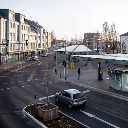 Auf der rechten Seite des Bildes sind der Bahnhofsvorplatz und ein Teil des Bahnhofsgebäudes in Euskirchen zu sehen.