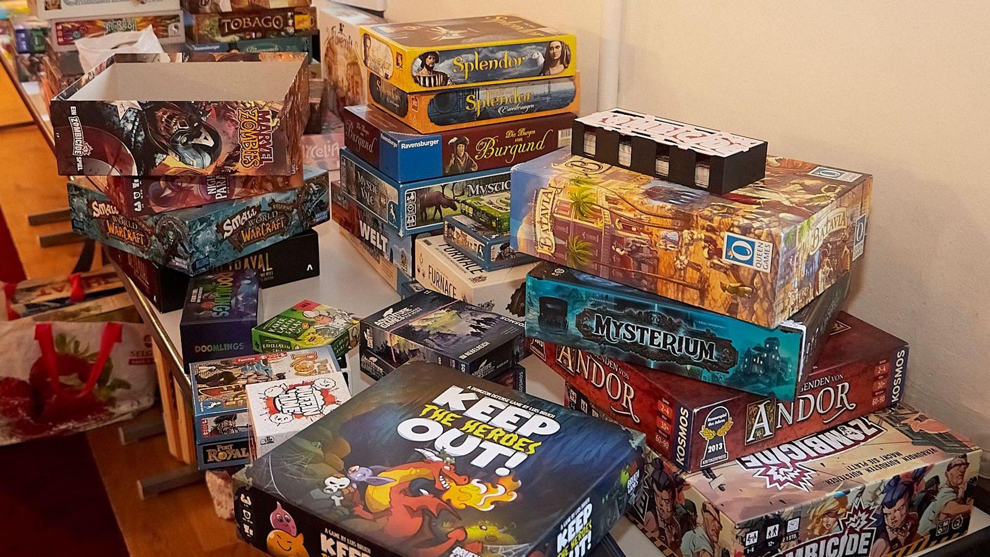 Auf einem Tisch stapeln sich viele Brettspiele.