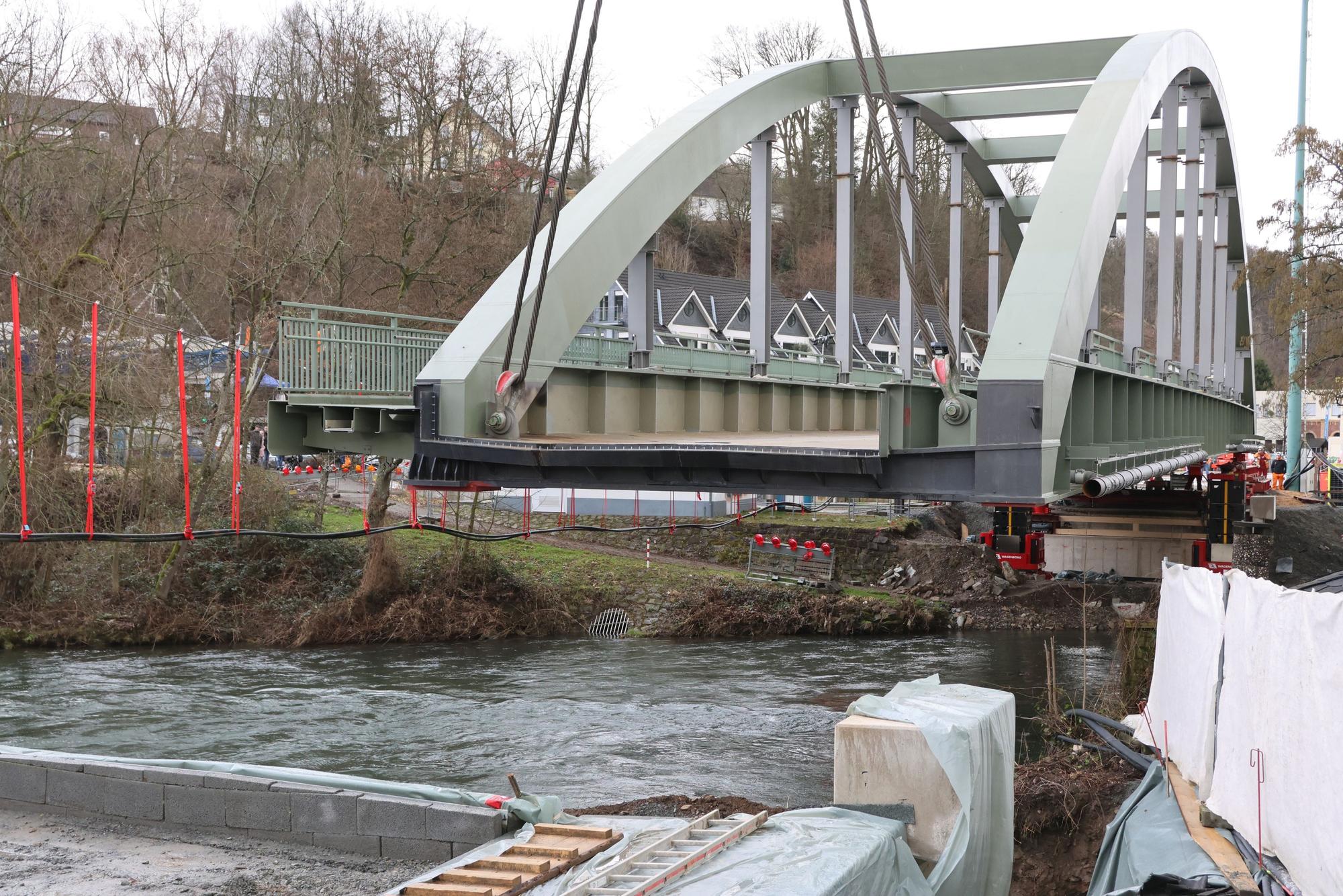 Eine Brücke hängt an Tauen über einem Fluss.