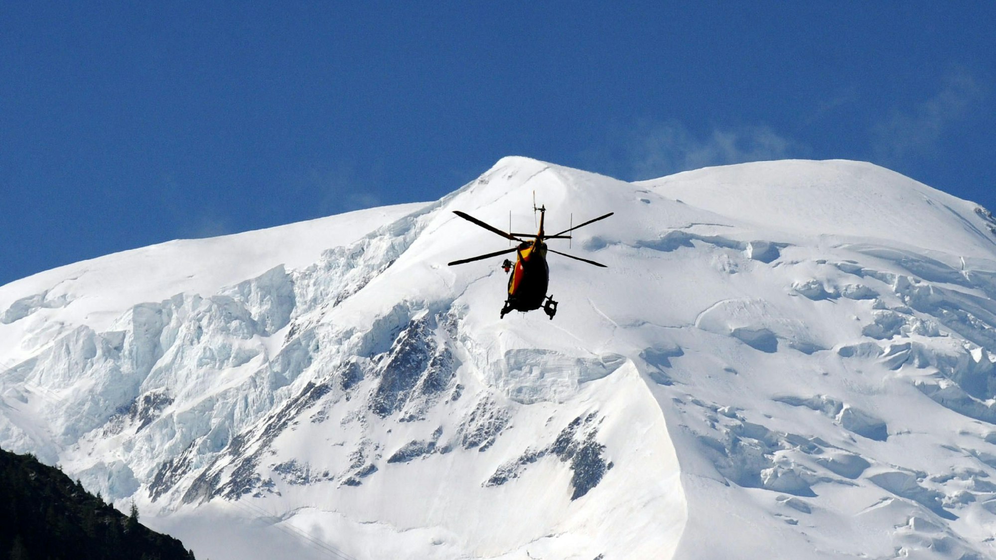 Ein Rettungshubschrauber fliegt über dem Zentralmassiv der französischen Alpen. (Symbolbild)