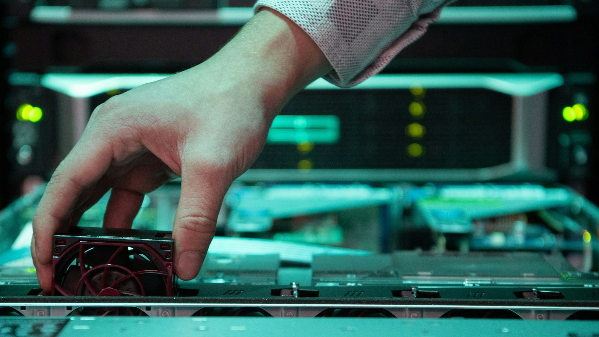 Ein Mitarbeiter eines IT-Unternehmens tauscht einen Lüfter an einem Server aus. Nicht nur in der Branche fehlen Fachkräfte.