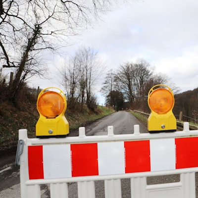 Eine Straße ist mit einer Bake und einem Durchfahrt-verboten-Schild gesperrt.