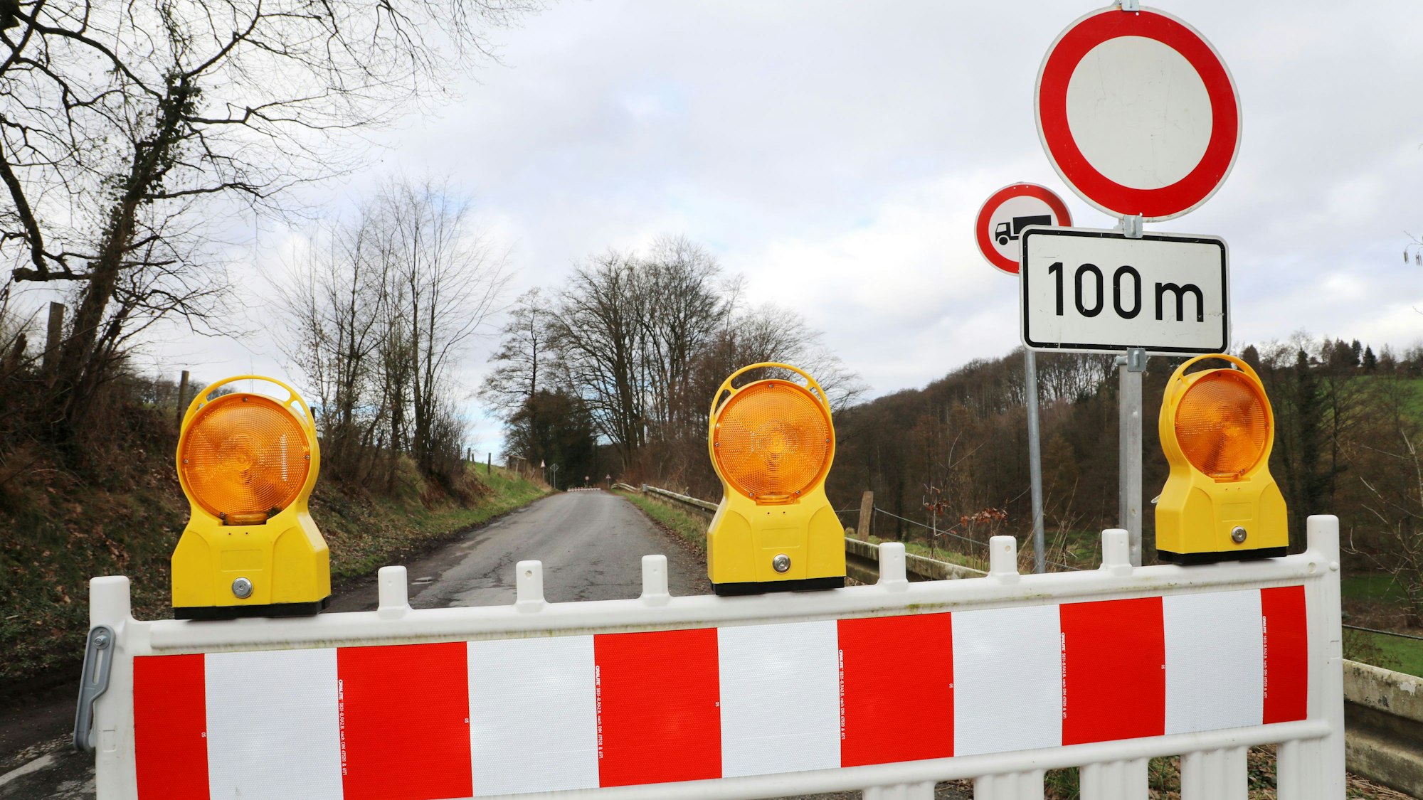 Eine Straße ist mit einer Bake und einem Durchfahrt-verboten-Schild gesperrt.