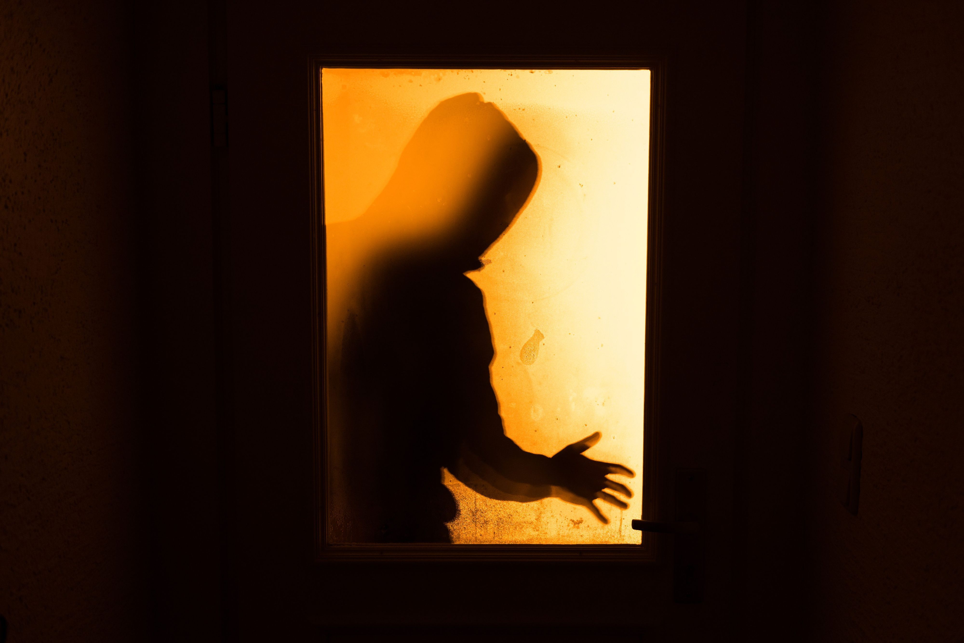 Das Bild zeigt eine Person hinter einer Glasscheibe.