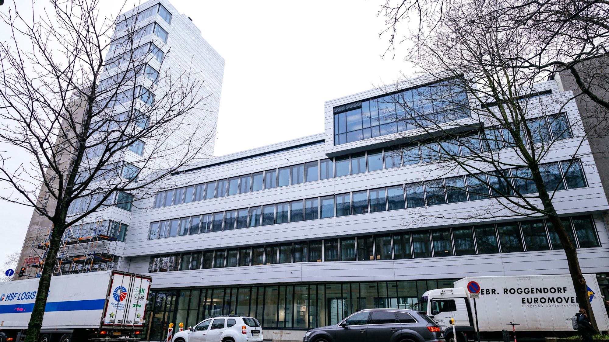 Ein Umzugswagen steht vor dem neuen Hauptgebäude der Kunsthochschule für Medien Köln in der Nähe des Heumarkts. Der Gebäuderiegel ist vier- bis fünfgeschossig, es schließt sich ein Turm mit elf Stockwerken an.