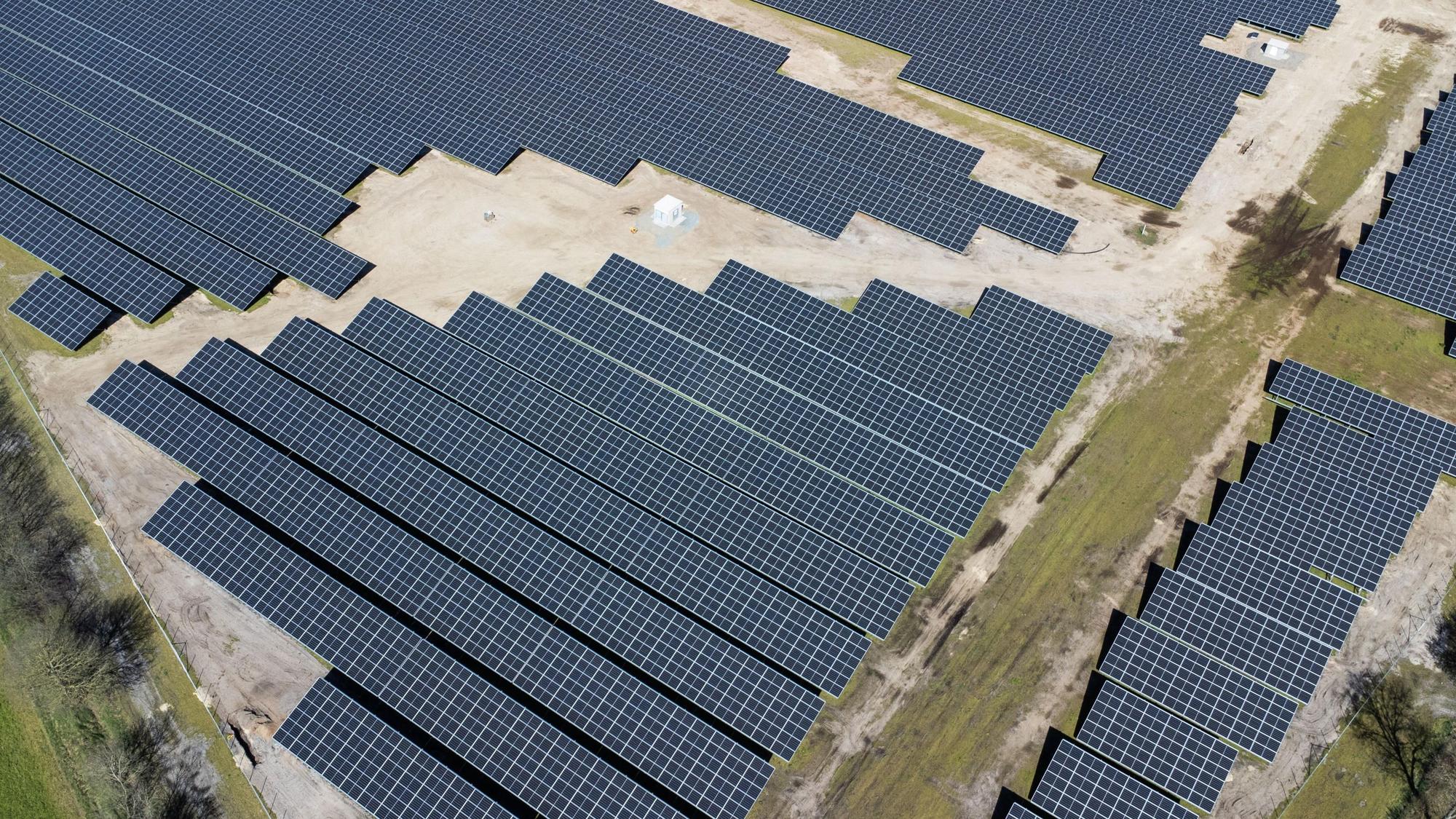 Eine neue Solaranlage steht neben Feldern und einer Autobahn.