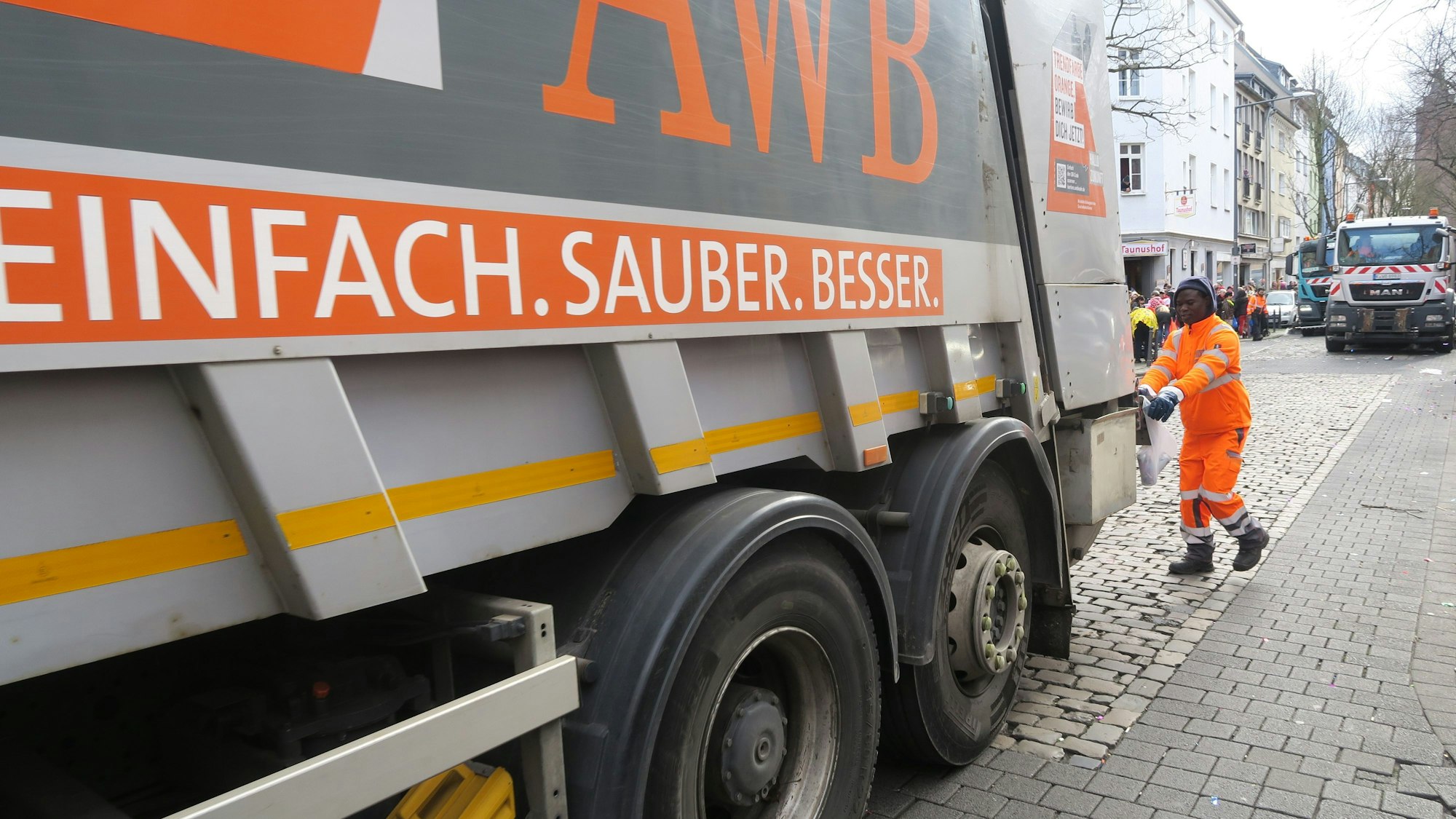 Ein Müllwagen der Abfallwirtschaftsbetriebe Köln steht auf einer Straße.