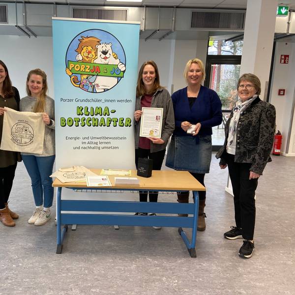 Junge und ältere Frauen stehen links und rechts von einem Aufsteller mit der Aufschrift Klimabotschafter.