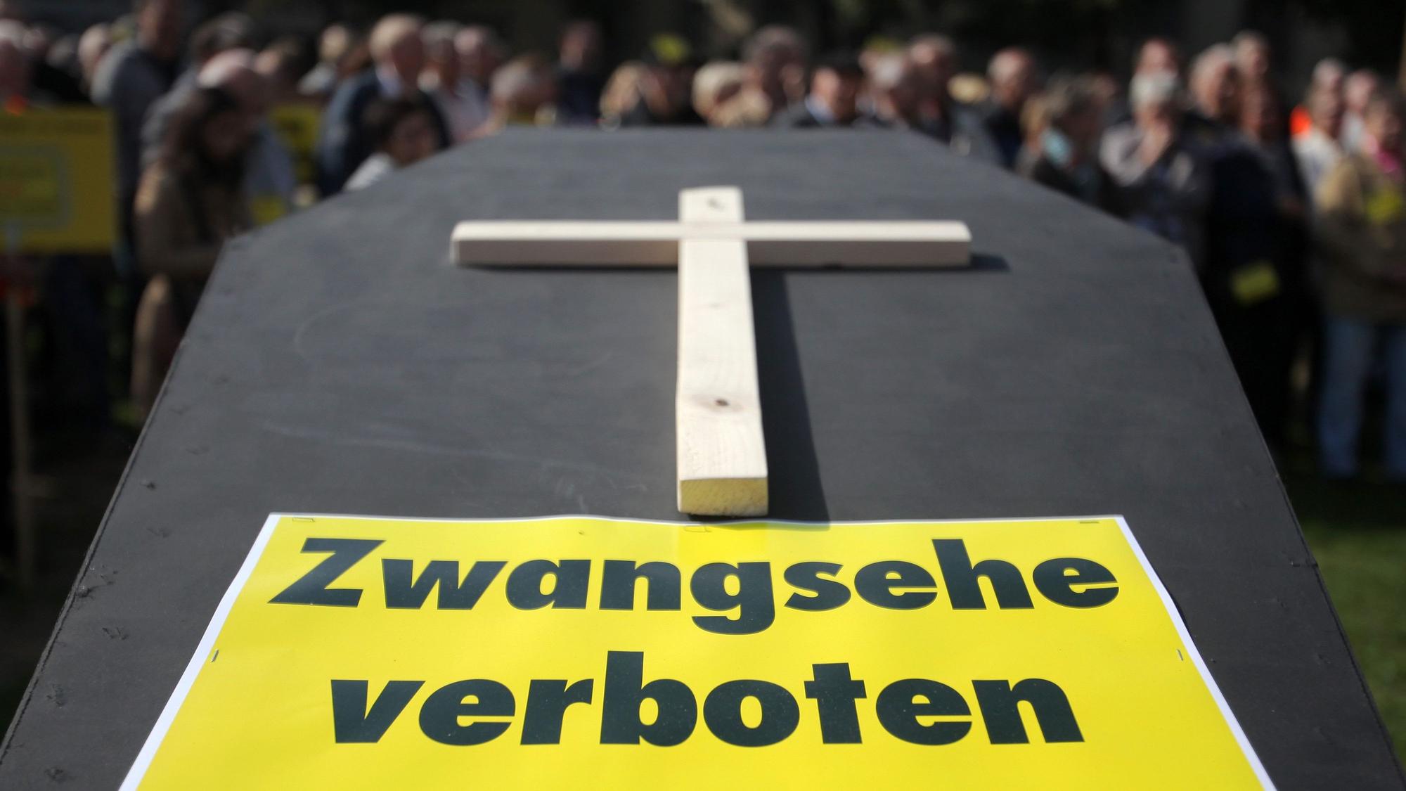Bei einer Demonstration gegen eine Kommunalreform steht vor dem Landtag in Mainz ein Sarg mit der Aufschrift „Zwangsehe verboten“. Ein Elternpaar soll in Spanien seine zwölfjährige Tochter für eine Zwangsheirat für 3000 Euro verkauft haben. (Archivbild)