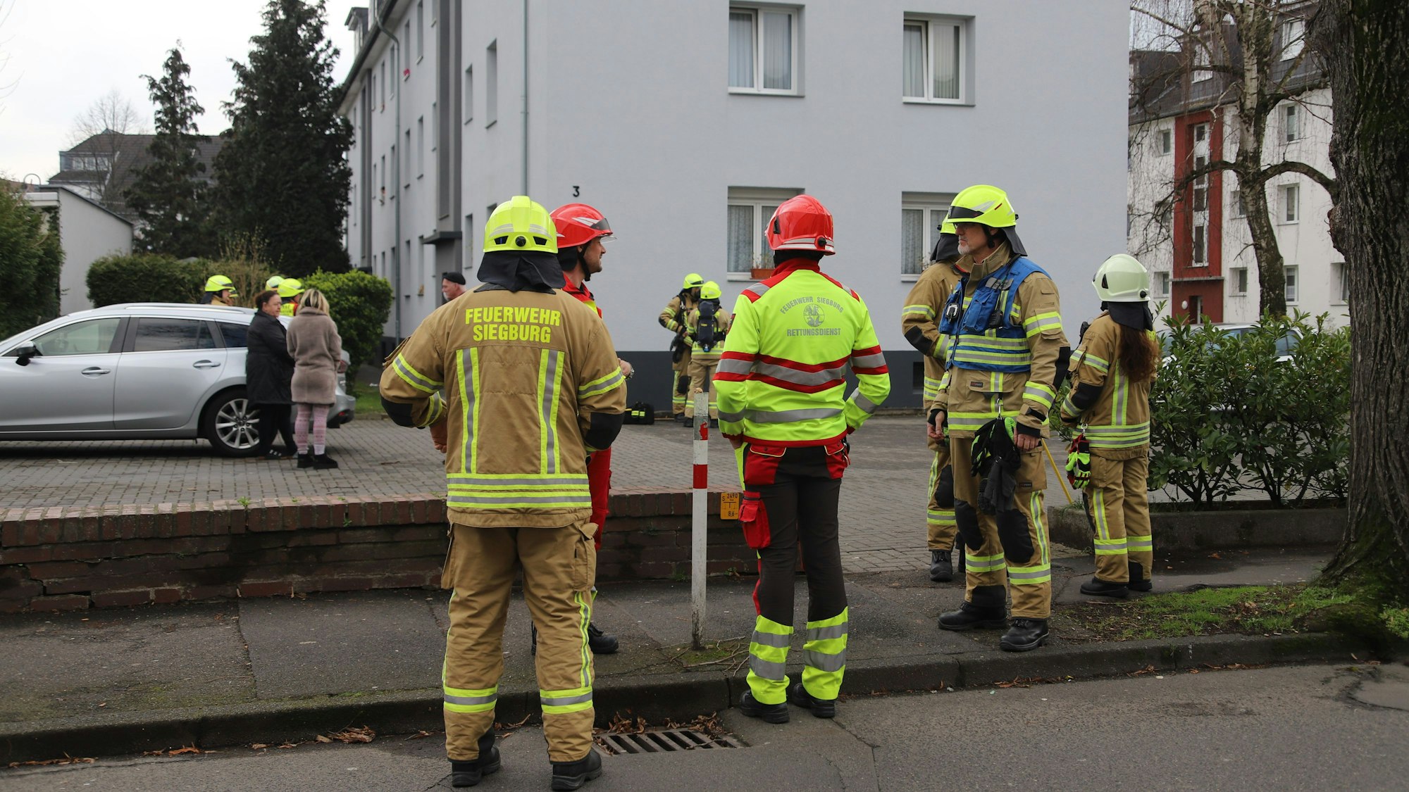 Feuerwehrleute berieten vor dem Gebäude über das weitere Vorgehen.