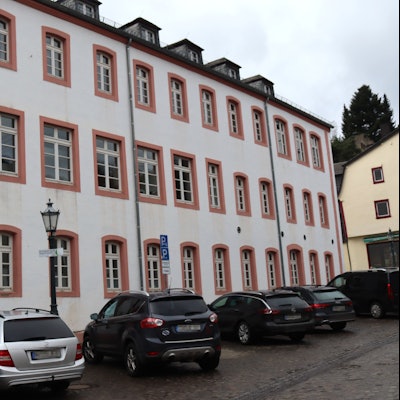Eine Außenansicht der Grundschule Bad Münstereifel, vor der Autos parken.