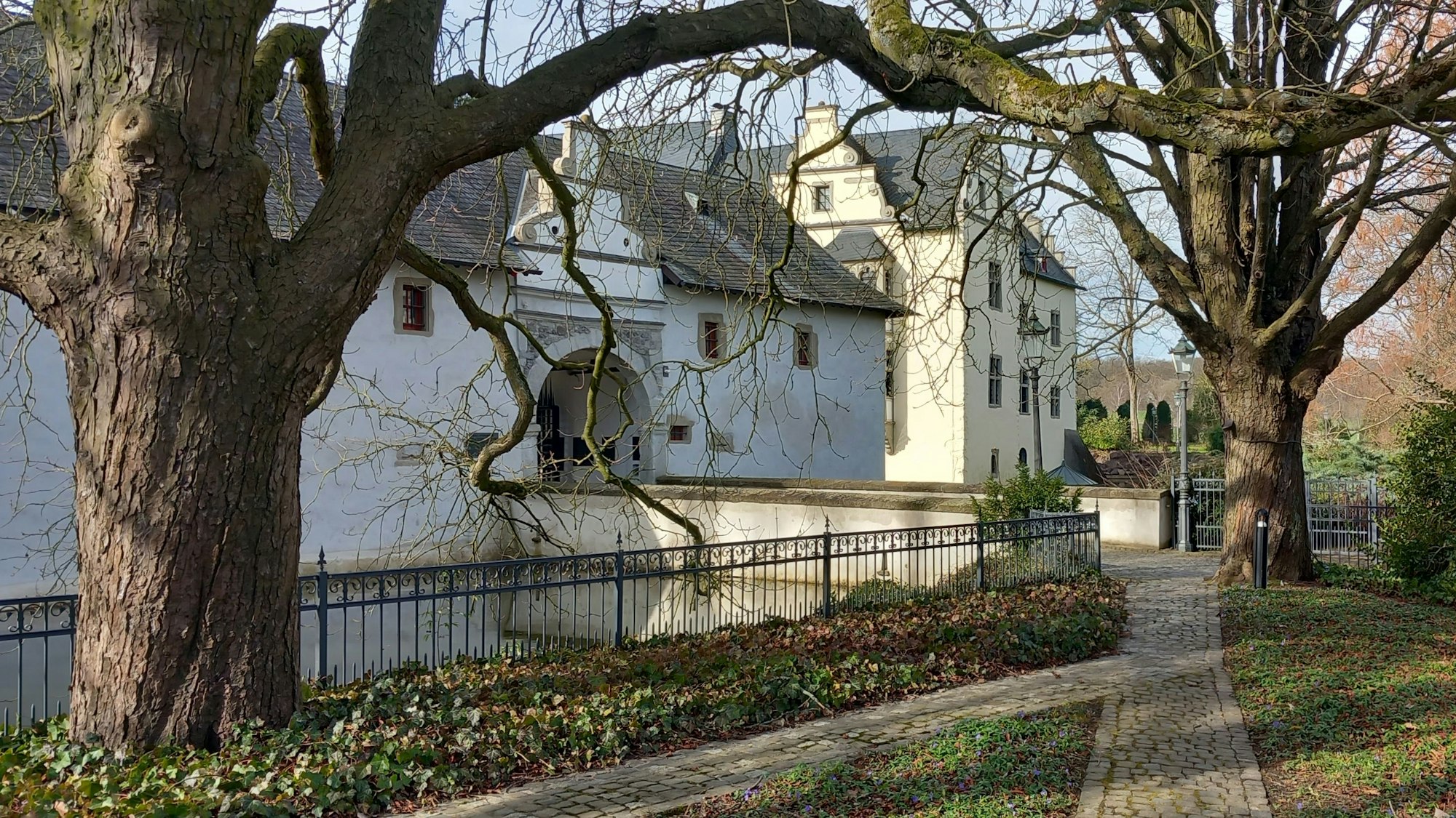 Hinter einem Wassergraben liegt am Rande von Berkum Burg Odenhausen