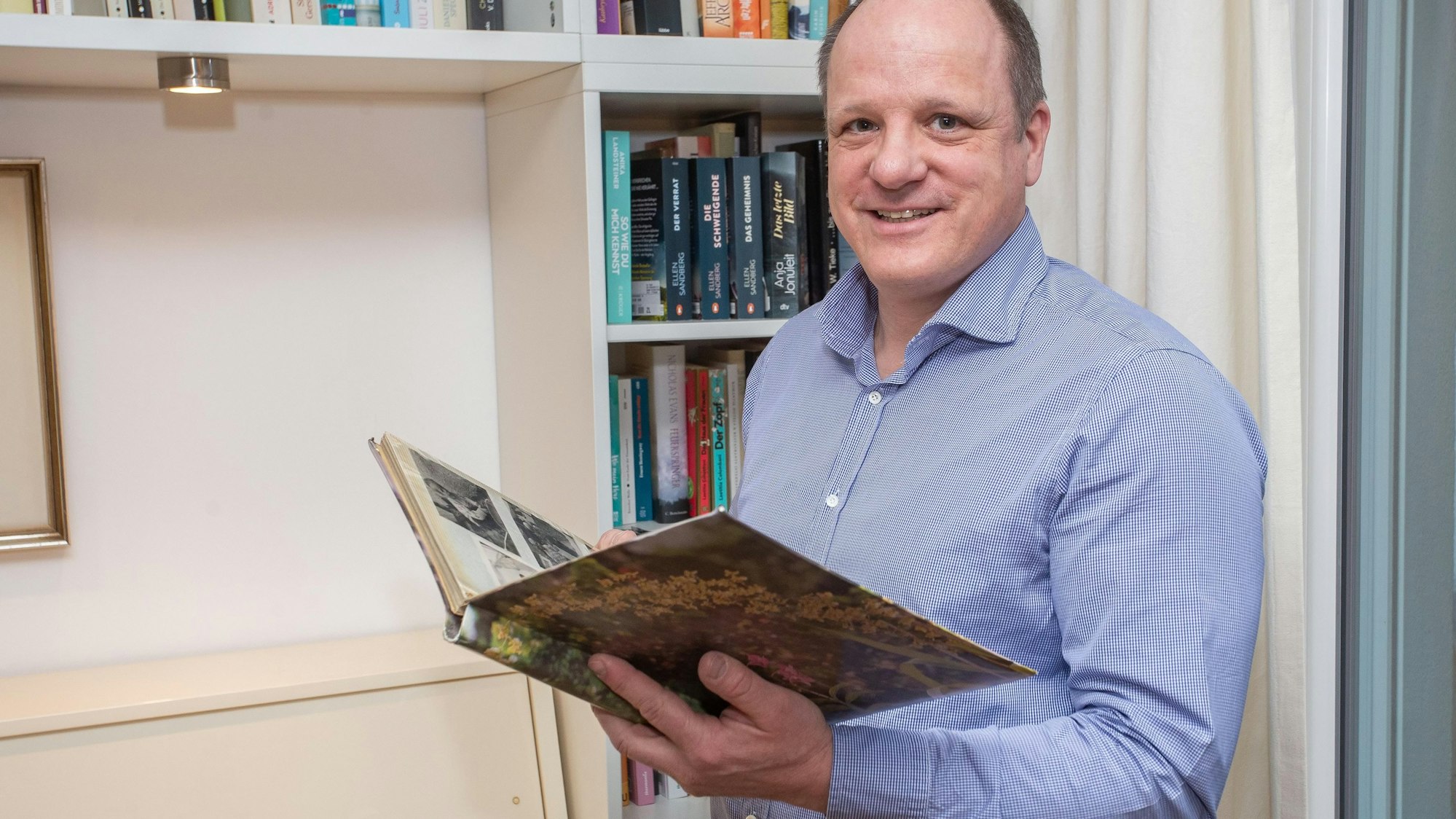 „Geburtstagskind“ Jörn Maiwald heute. Der nun 56-Jährige aus Bergneustadt hält das Fotoalbum in den Händen, in dem seine Mutter Inge seine Kindheit festgehalten hat – darin findet sich auch der Bericht aus dieser Zeitung über die Geburt von insgesamt fünf „Schalttagskindern“.