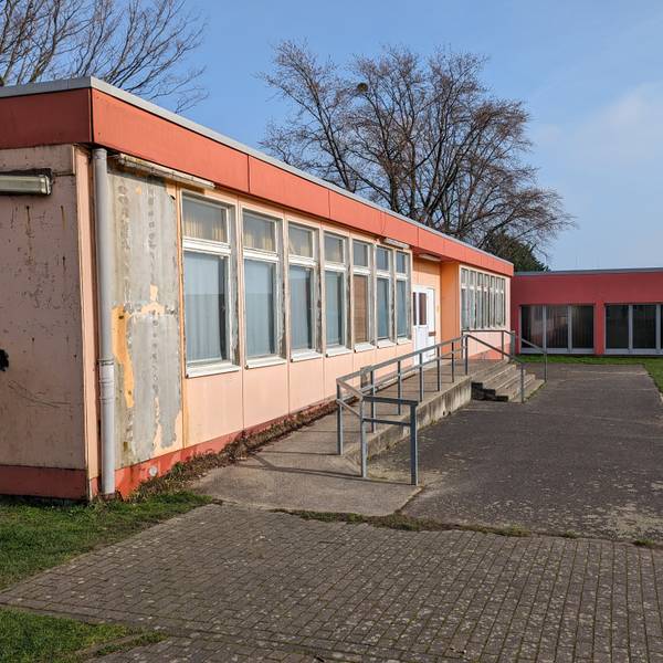Ein maroder Pavillon mit abgeblätterter Farbe an der Fassade auf dem Schulhof der Martinusschule in Fischenich.