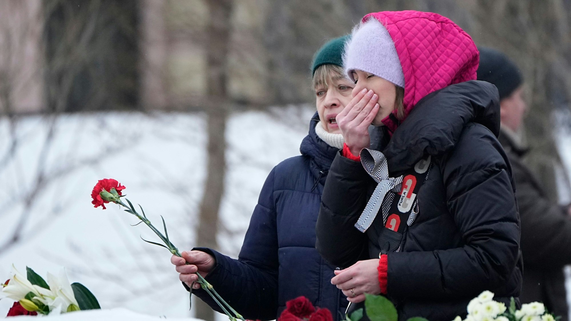 Frauen legen an einem Denkmal Blumen nieder, um Alexej Nawalny die letzte Ehre zu erweisen. Am Freitag soll Nawalny in Moskau beerdigt werden. Symbolbild)