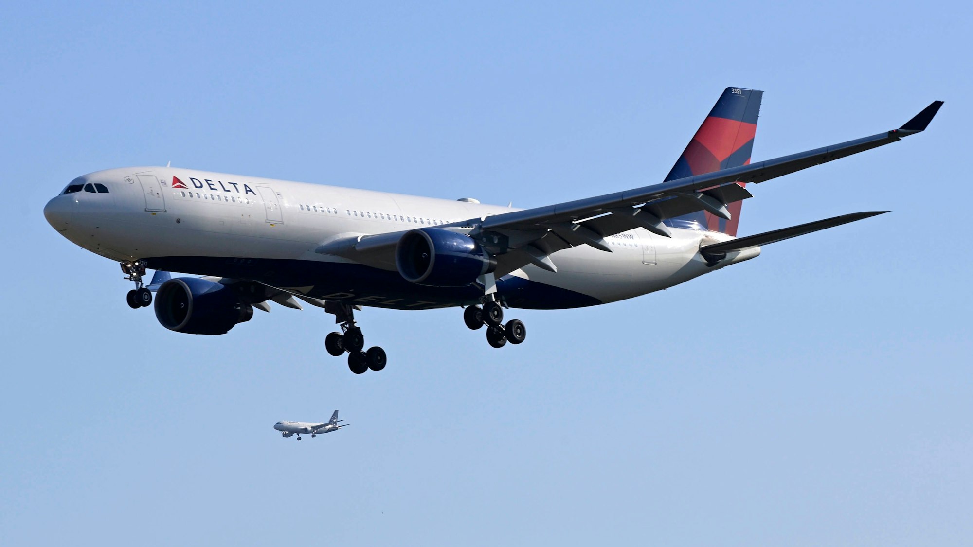 Ein Airbus A330 der US-Fluggesellschaft Delta Airlines im Landeanflug am Flughafen Frankfurt am Main. Im Hintergrund ist ein weiteres Passagierflugzeug zu sehen. (Symbolbild)