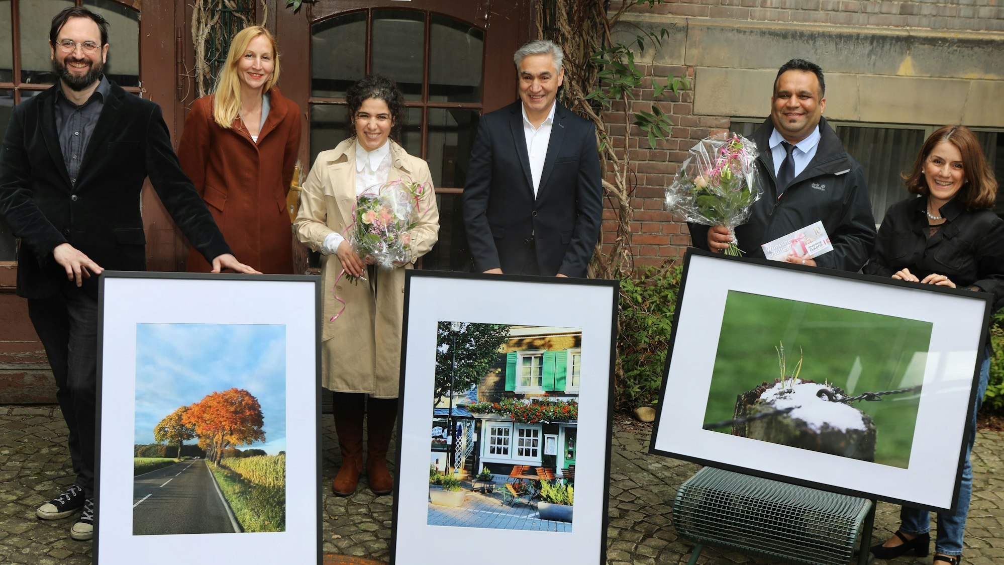 Amtsleiterin Tiemann (2.v.l.) mit Preisträgern, die ihre Bilder präsentieren.