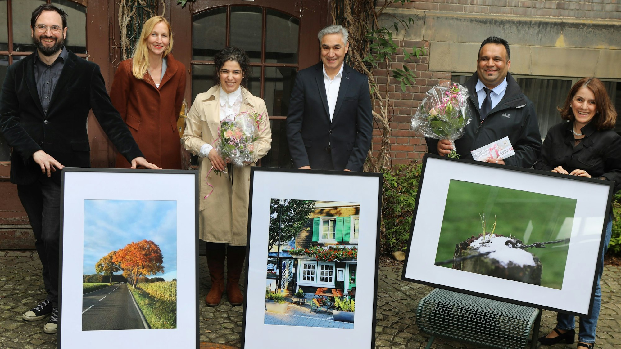 Amtsleiterin Tiemann (2.v.l.) mit Preisträgern, die ihre Bilder präsentieren.