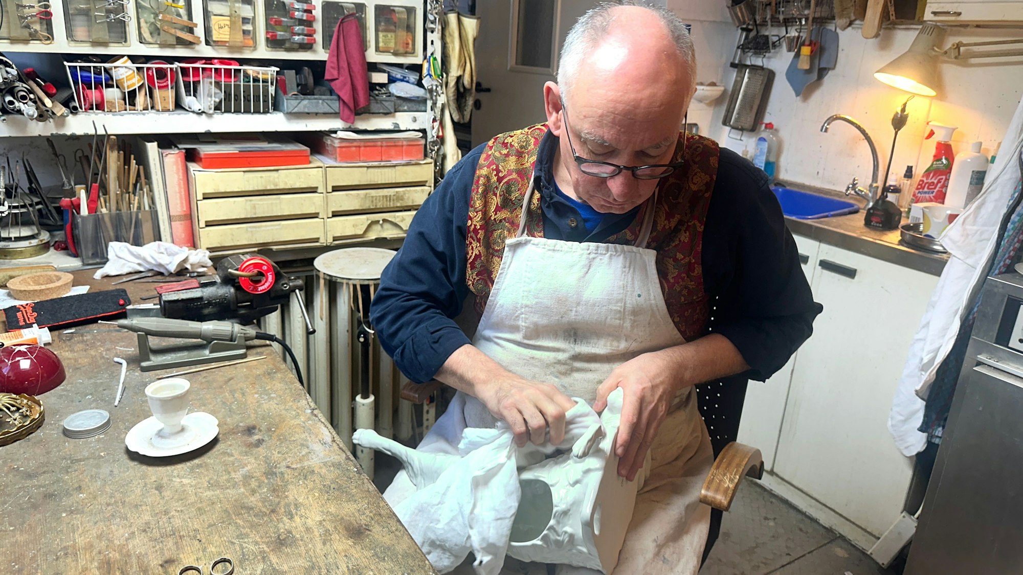 Ein Mann poliert eine weiße Porzellan-Figur.