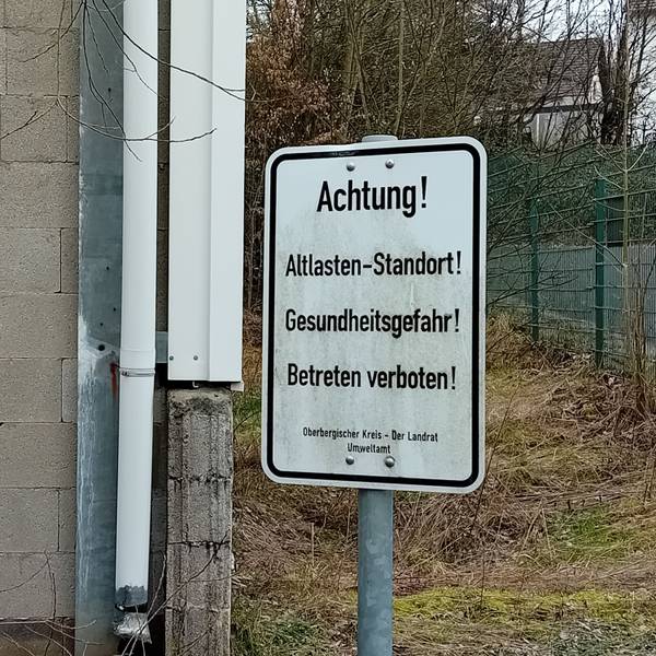 Ein Schild warnt „vor Gesundheitsgefahr!“.