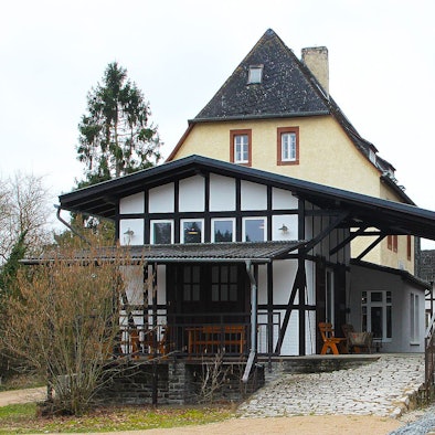 Neben dem Gebäude des Museumsbanhnhofs steht ein roter Schienenbus auf den Gleisen.