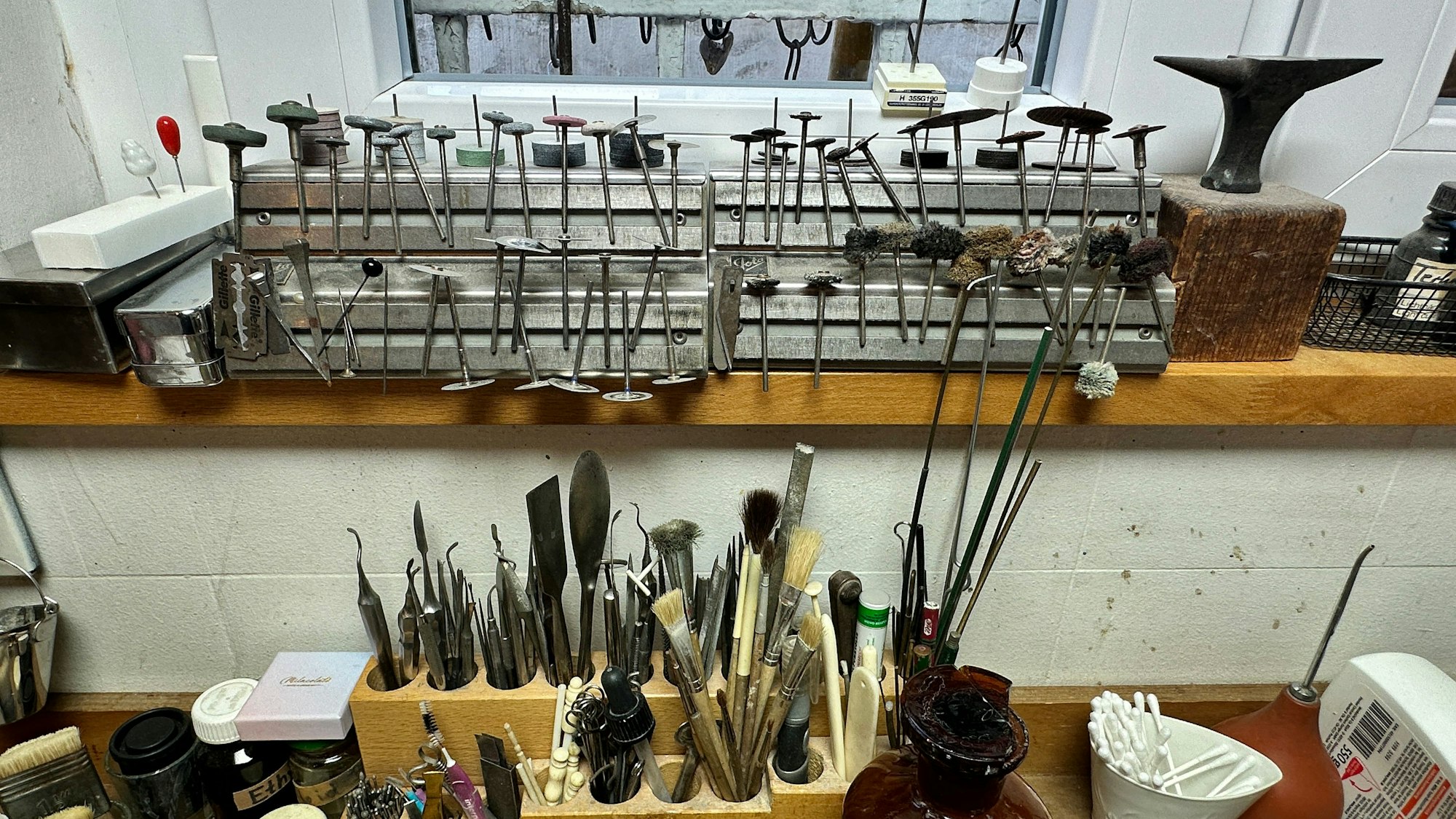 In verschiedenen Halterungen stehen filigrane Werkzeuge, die an Zahnarzt-Instrumente erinnern.