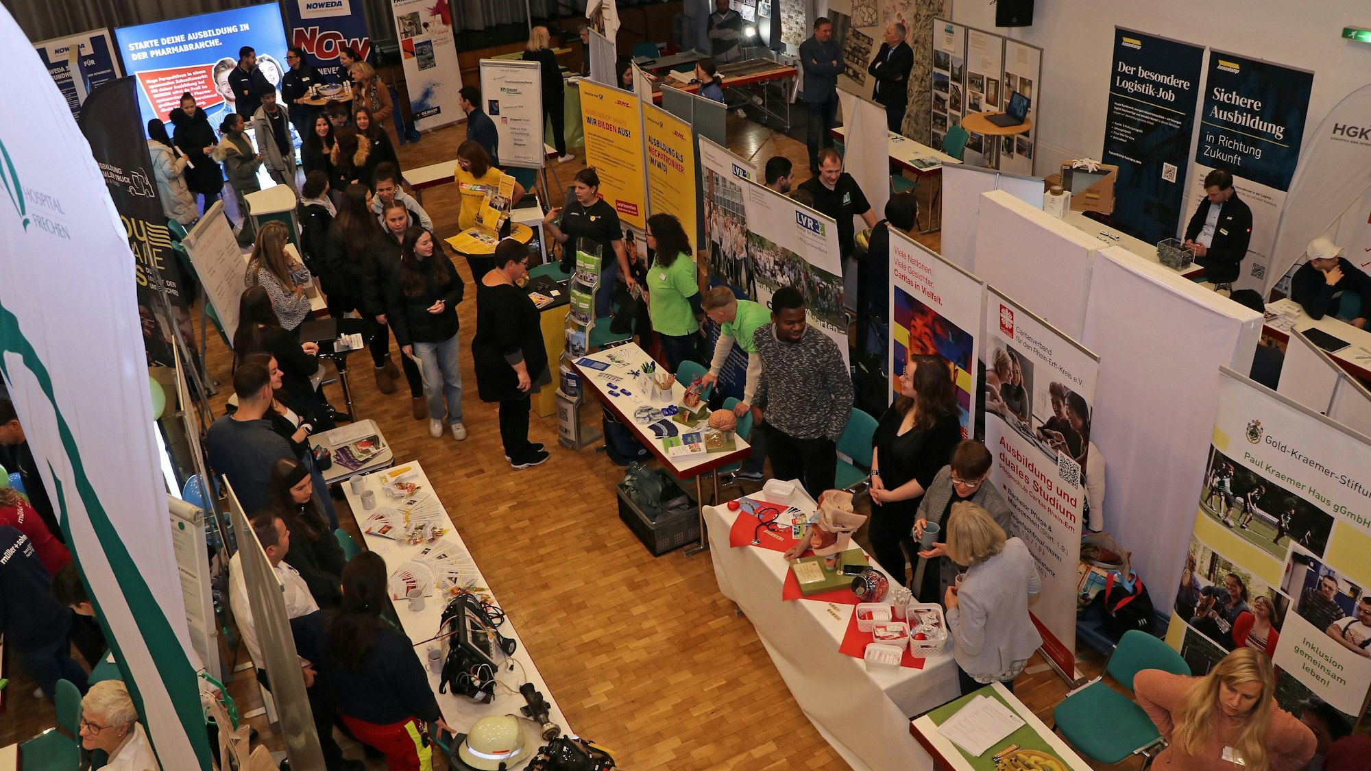 Zu sehen ist ein großer Raum mit vielen Infoständen.
