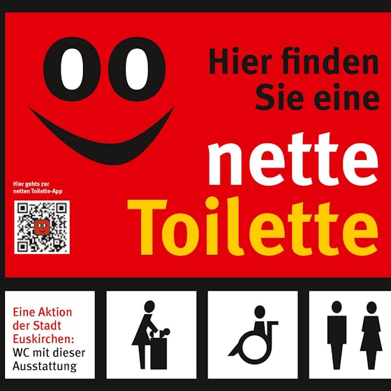 Auf dem Aufkleber steht: Hier finden Sie eine nette Toilette. Neben dem Schriftzug befindet sich ein stilisiertes Gesicht, dessen Augen mit zwei Nullen, dem WC-Symbol, dargestellt werden.