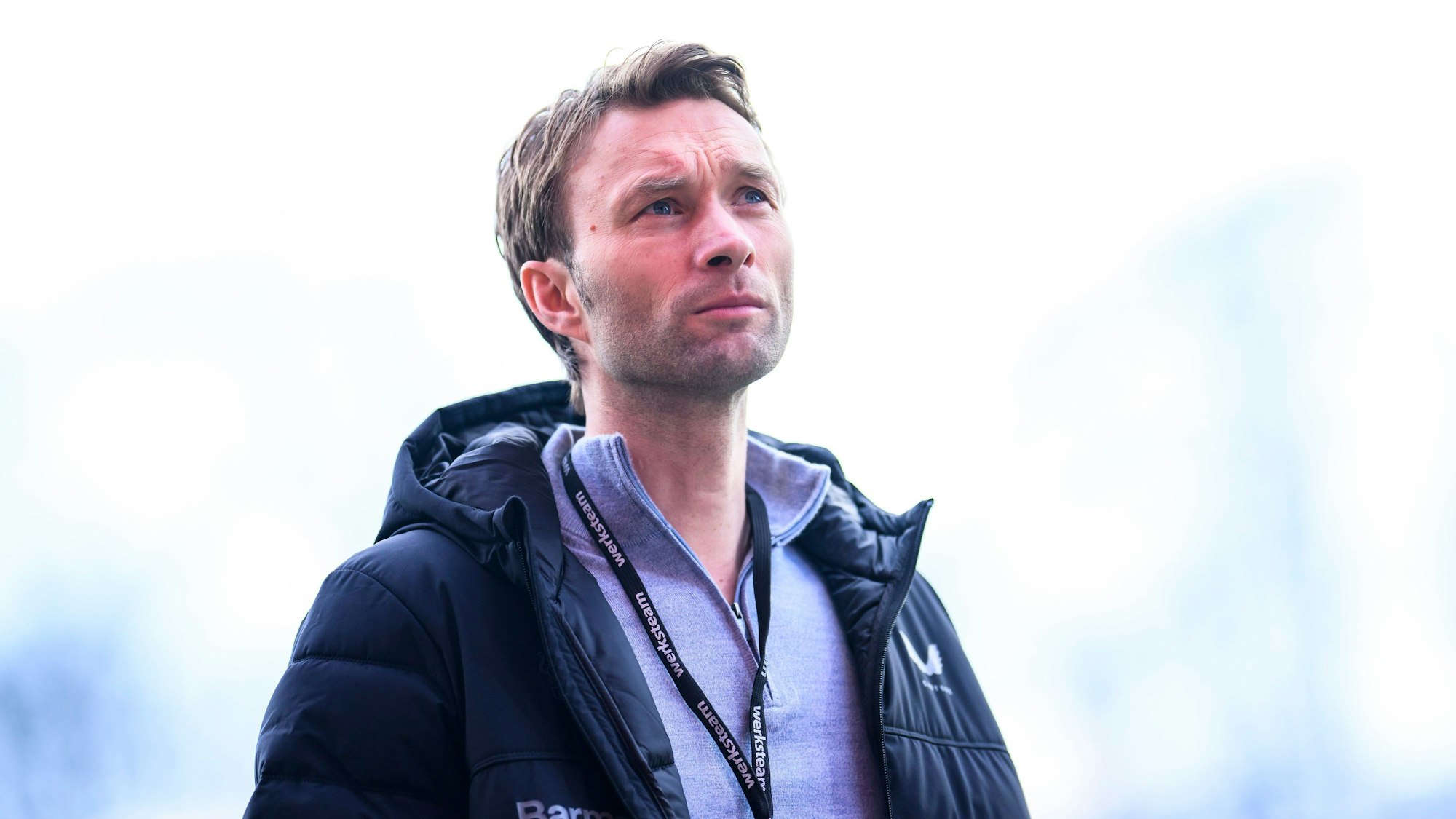 Leverkusens Sportdirektor Simon Rolfes steht vor dem Spiel im Stadion.