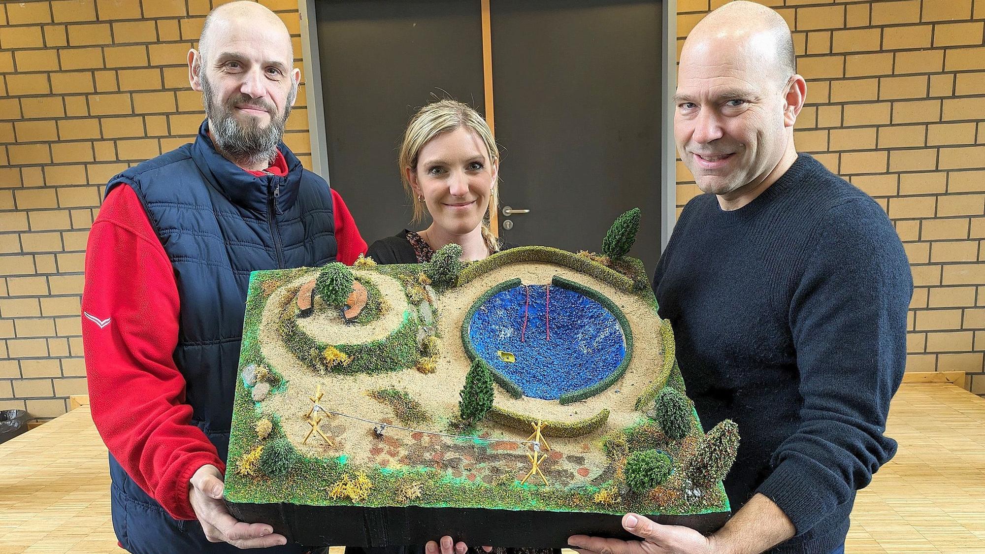 Christoph Nagel und Sarah Rösgen vom Förderverein sowie Schulleiter André Decker (r.) haben ein Modell des neuen Pausenhofes in der Hand.