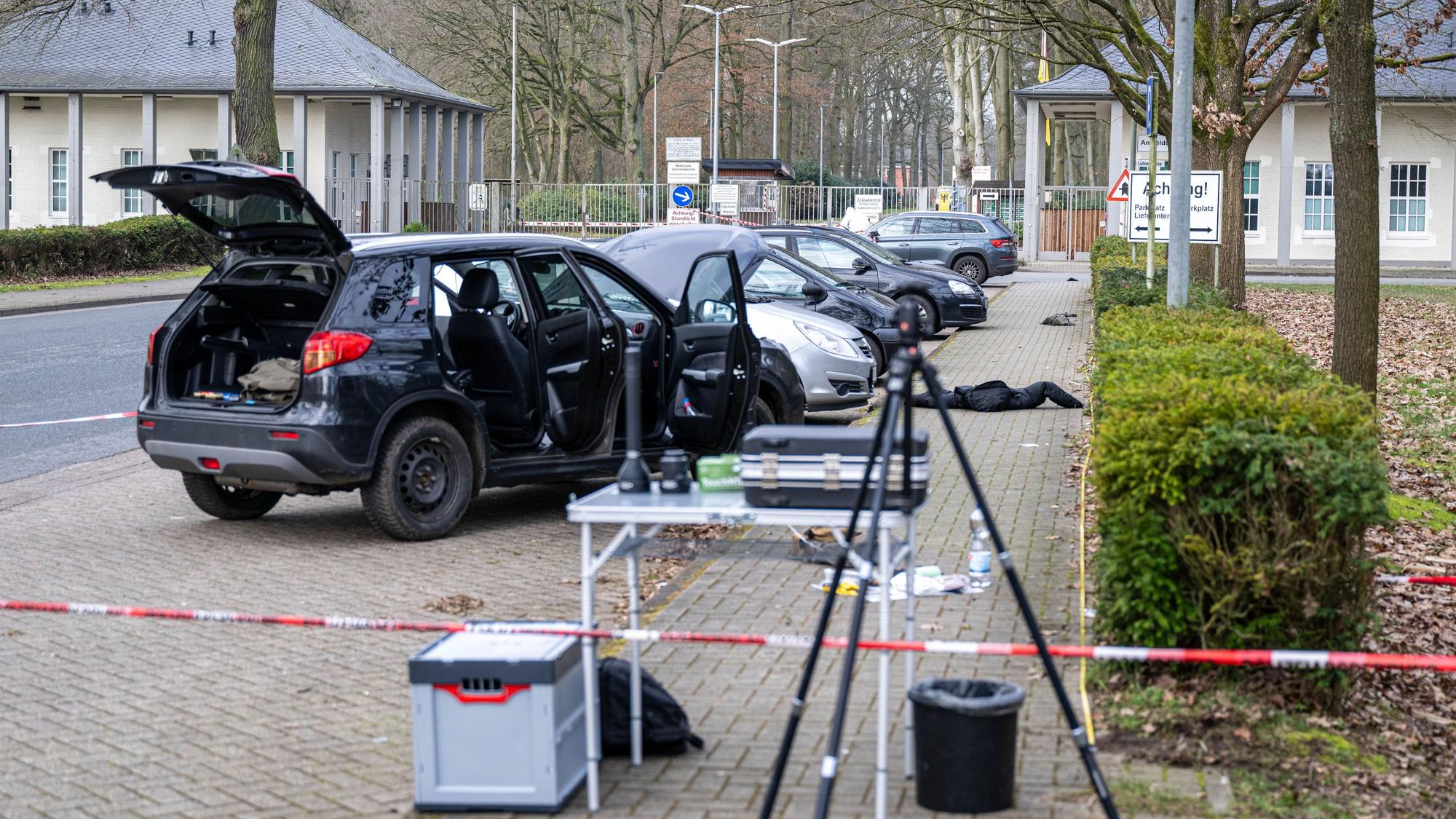 Ein Auto steht hinter einem Absperrband in der Nähe einer Kaserne.