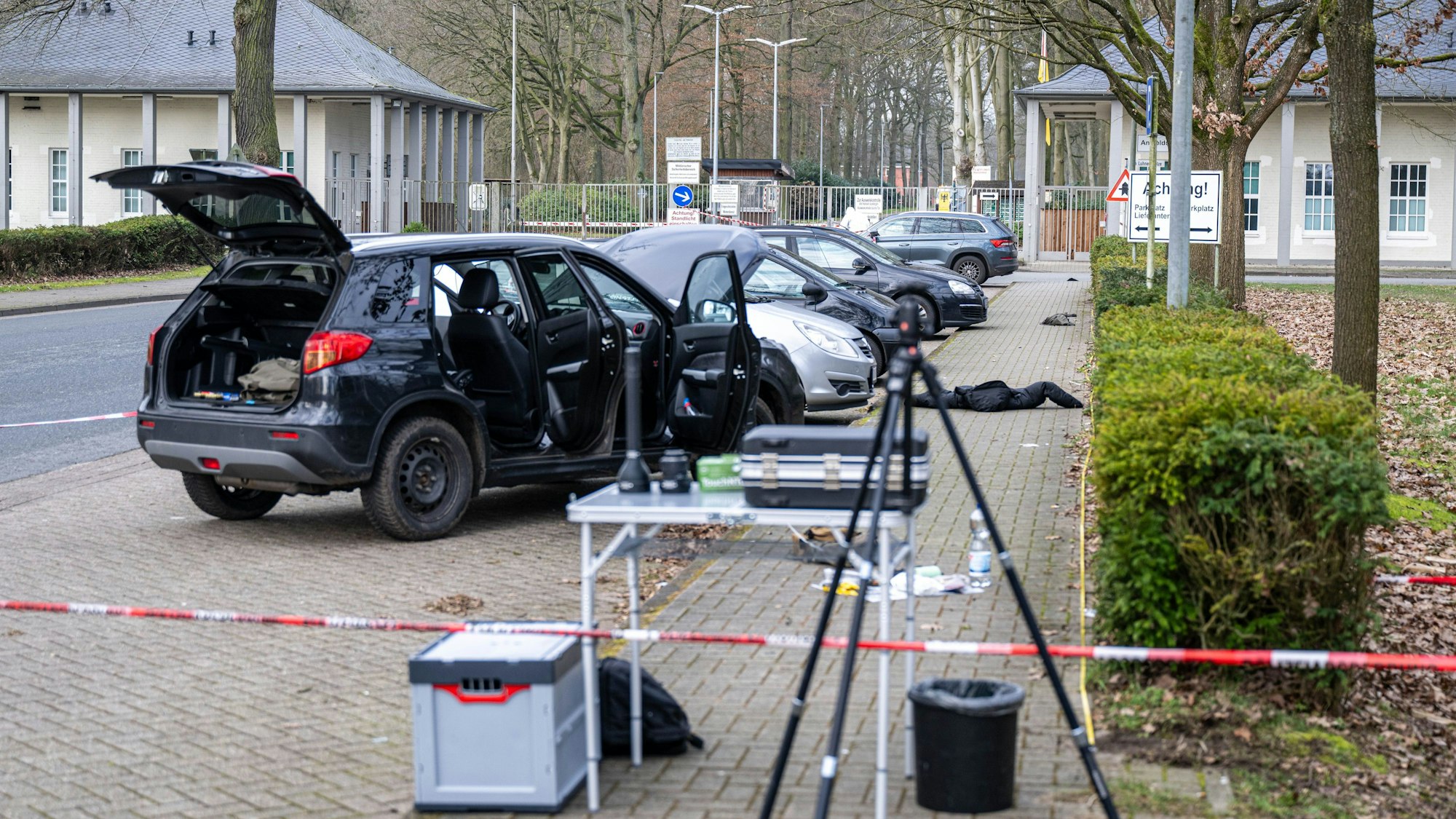 Ein Auto steht hinter einem Absperrband in der Nähe einer Kaserne.