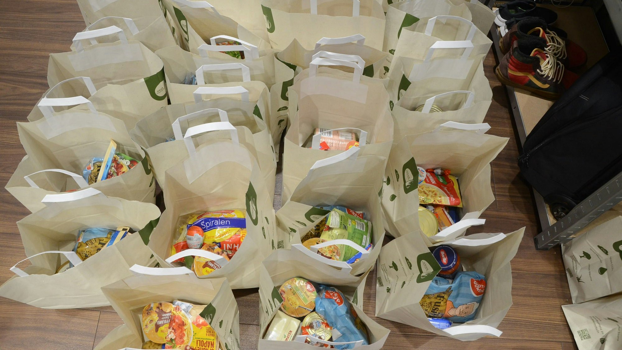 Viele weiße Papiertragetaschen. Sie sind gefüllt mit haltbaren Lebensmitteln.