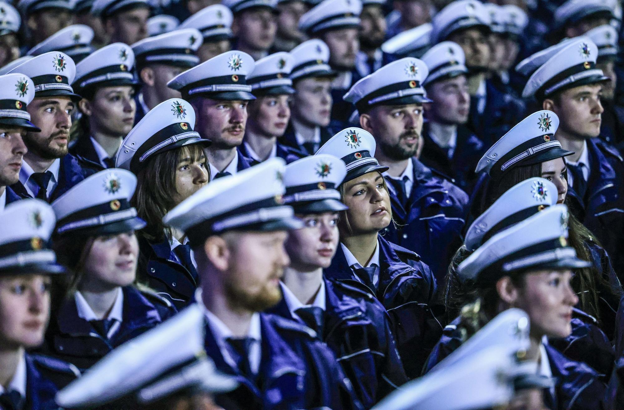 In der Lanxess-Arena sind, teilweise von blauem Licht angestrahlt, mehr als 3000 angehende Polizistinnen und Polizisten vereidigt worden.
