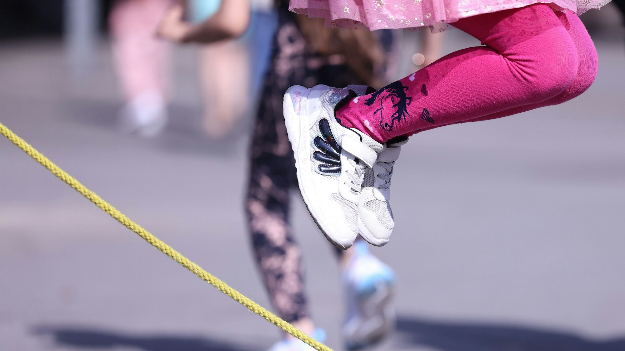 Ein Kind macht Seilhüpfen auf dem Schulhof einer Gemeinschaftsgrundschule.