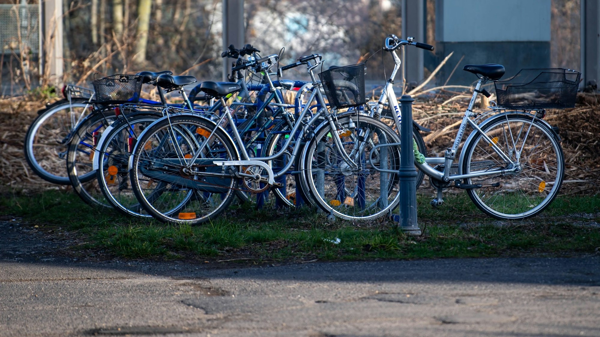 Das Bild zeigt einige Fahrräder, die am Bahnhof in Kuchenheim abgestellt sind.