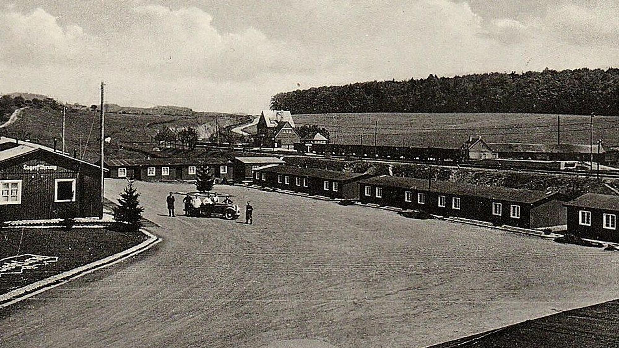 Das Bild zeigt eine Postkarte in schwarz-weiß. Darauf das einstige Reichsarbeitsdienstlager am Bahnhof in Blankenheim.