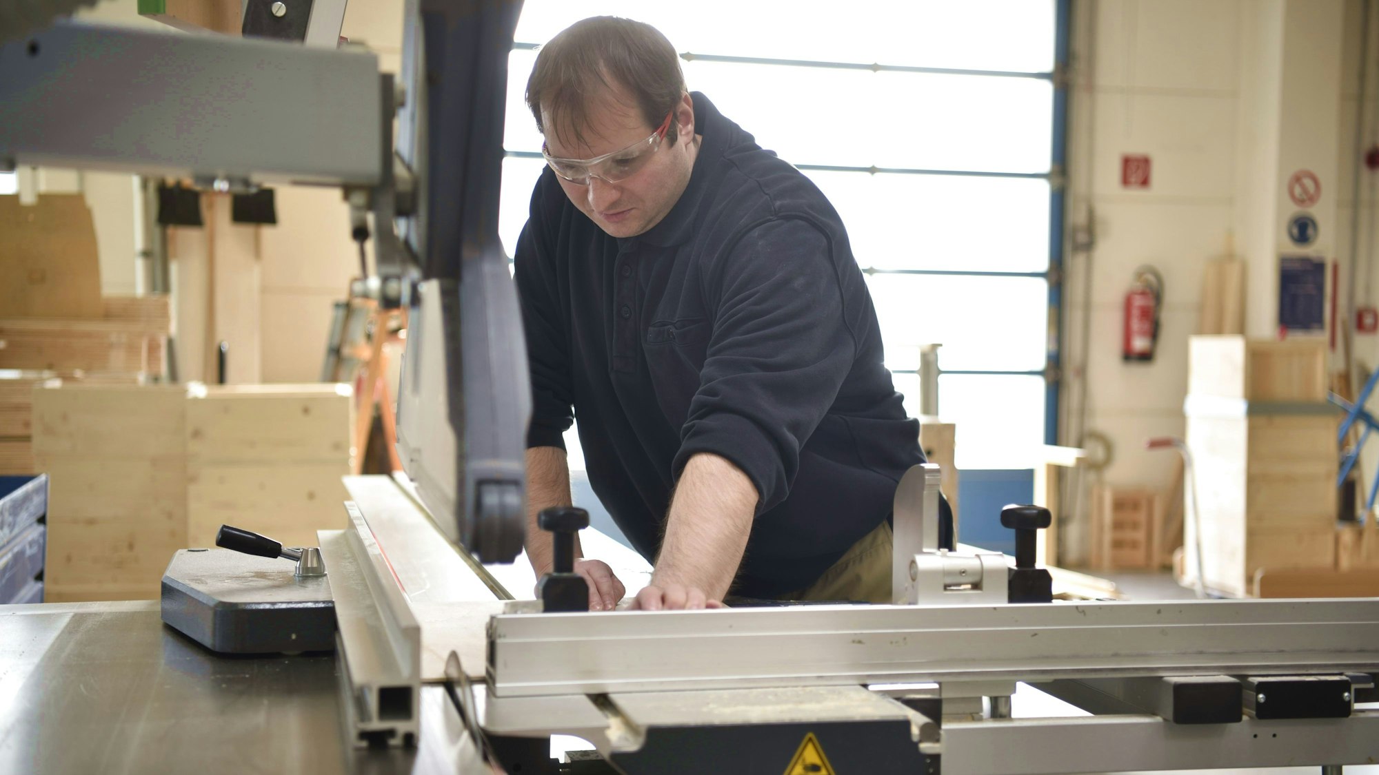 Sascha Breidenbach sägt in der Schreinerei der Nordeifelwerkstätten ein Brett zurecht.