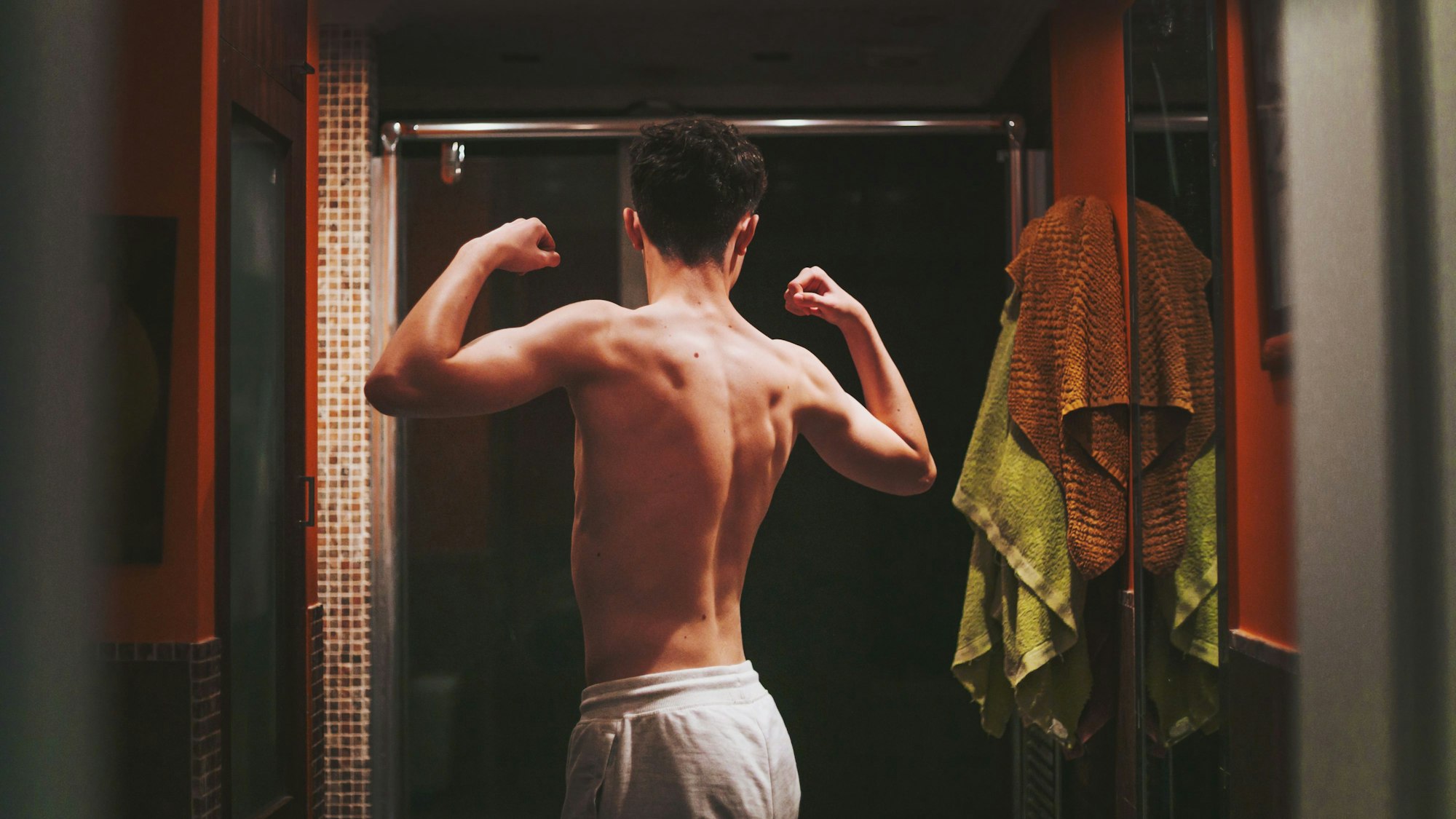 Ein Junge steht oberkörperfrei im Badezimmer