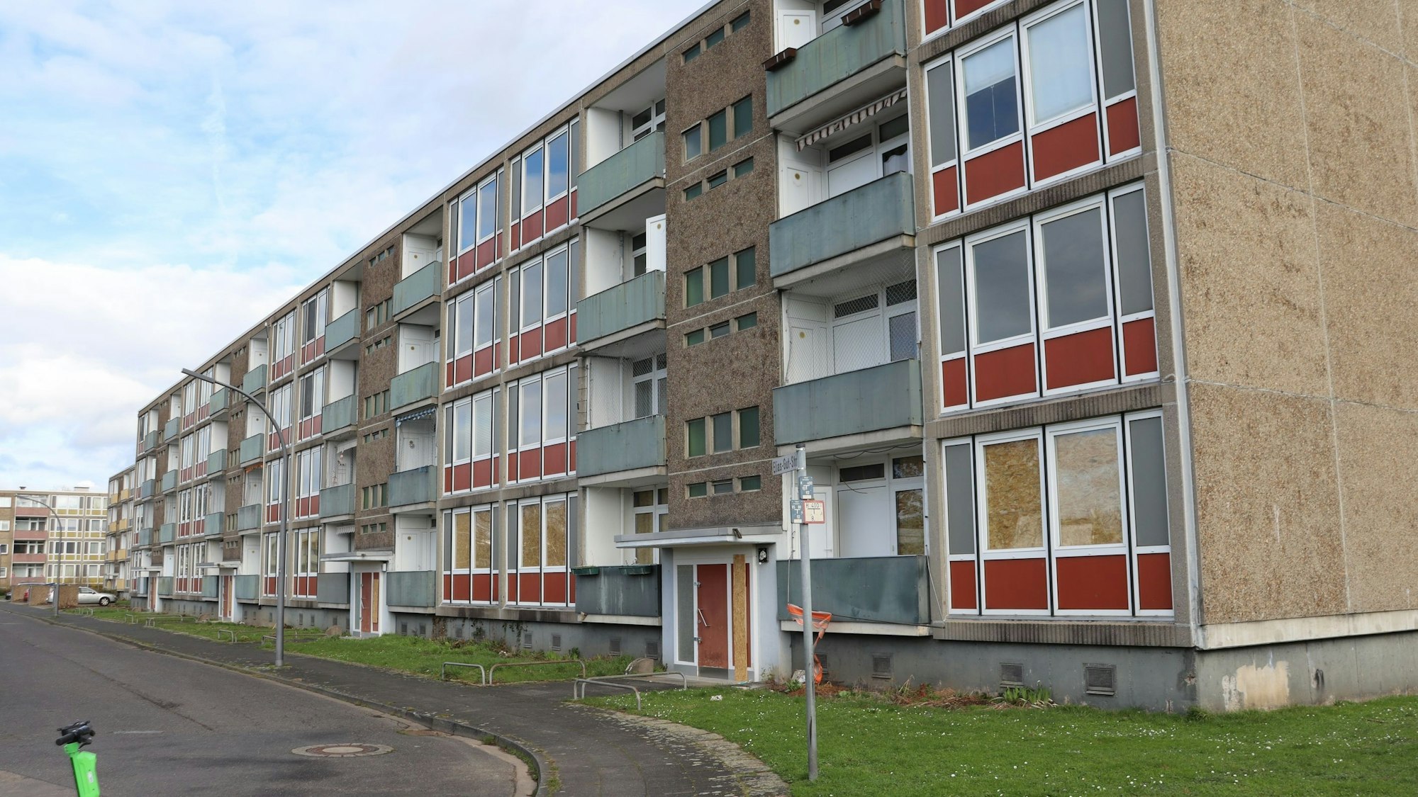 Blick auf ein vierstöckiges, verwahrlostes Wohngebäude