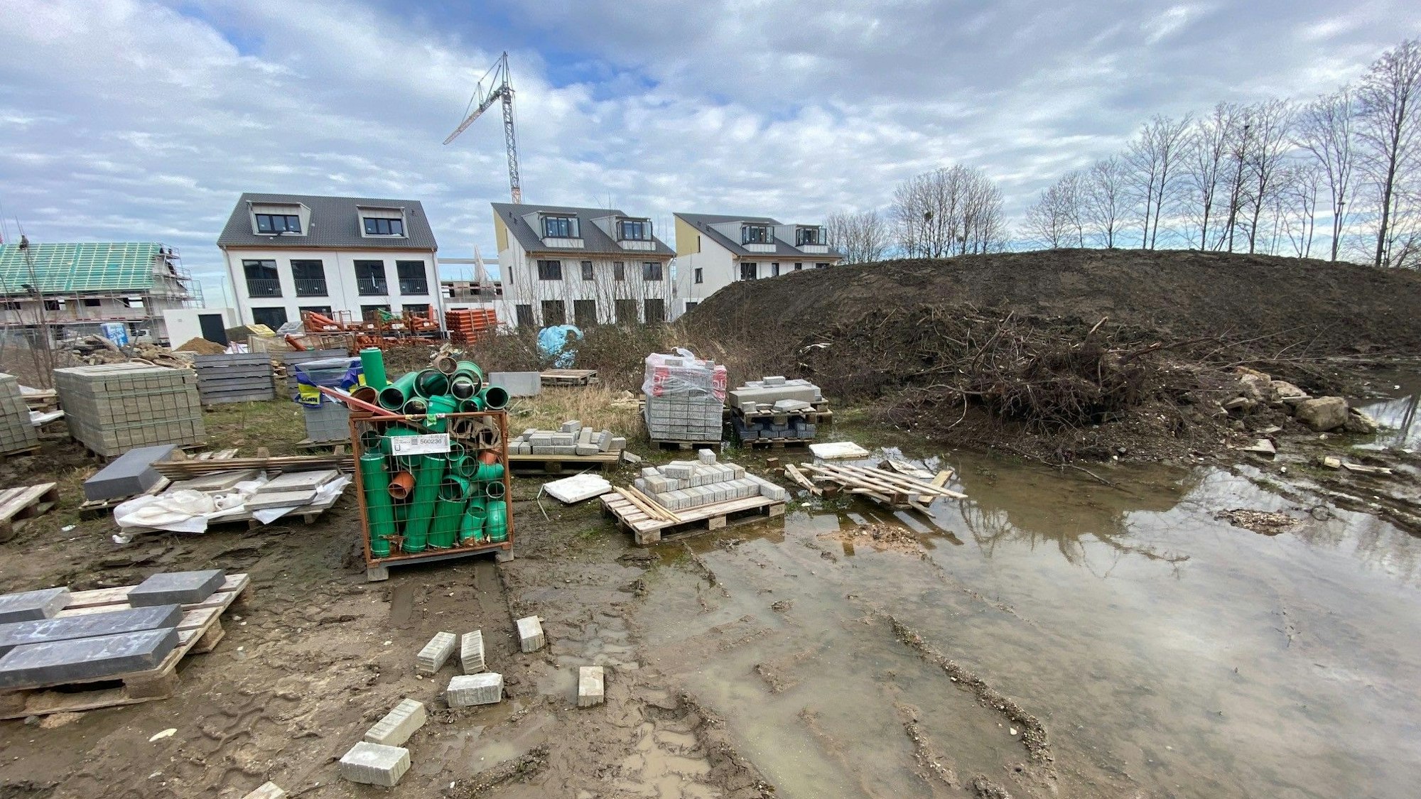 Zu sehen ist das Neubaugebiet als Baustelle, im Hintergrund Häuser.
