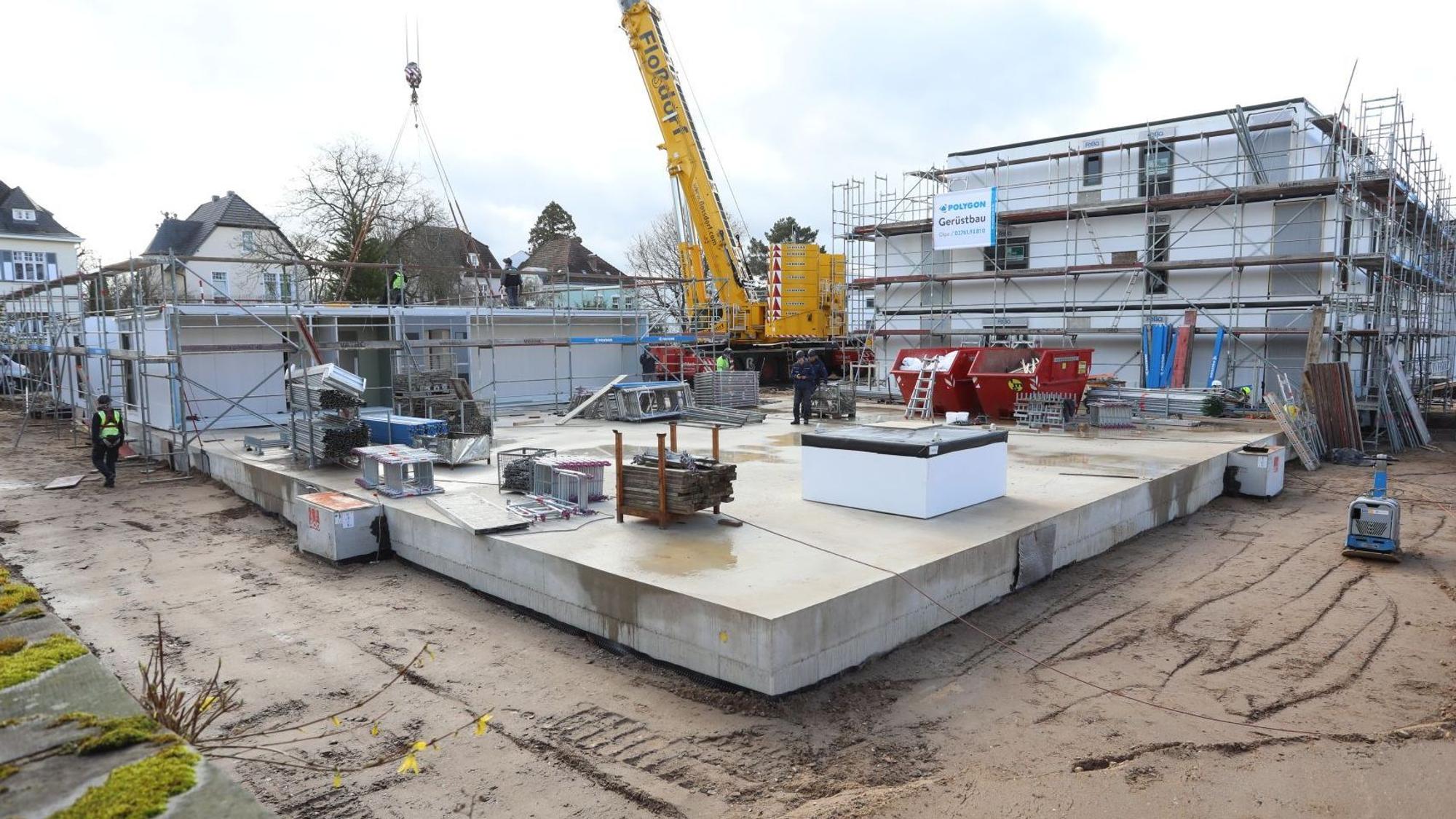 Eine Baustelle mit einem gelben Kran in der Mitte.