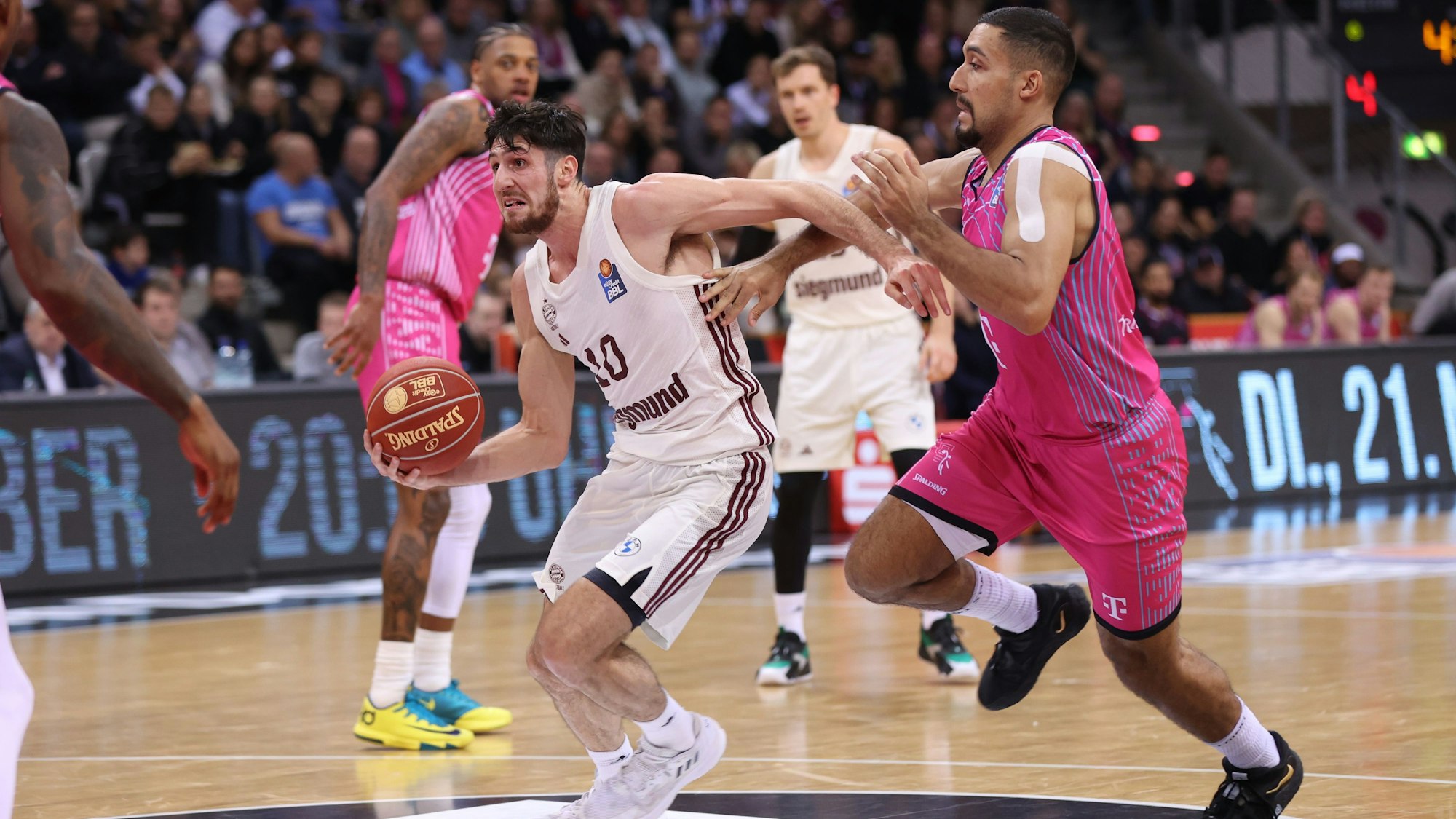 Laufduell zwischen Bayern-Spieler Leandro Bolmaro (l.) und Baskets-Forward Noah Kirkwood.
