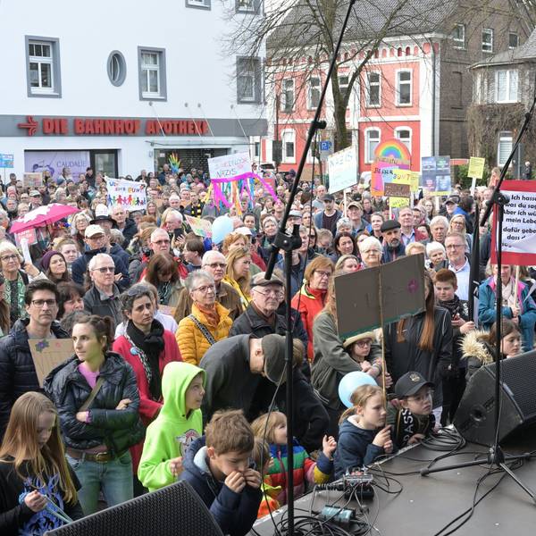 Andreas Heider steht auf einer Bühne vor Demonstrierenden auf dem Overather Bahnhofplatz.