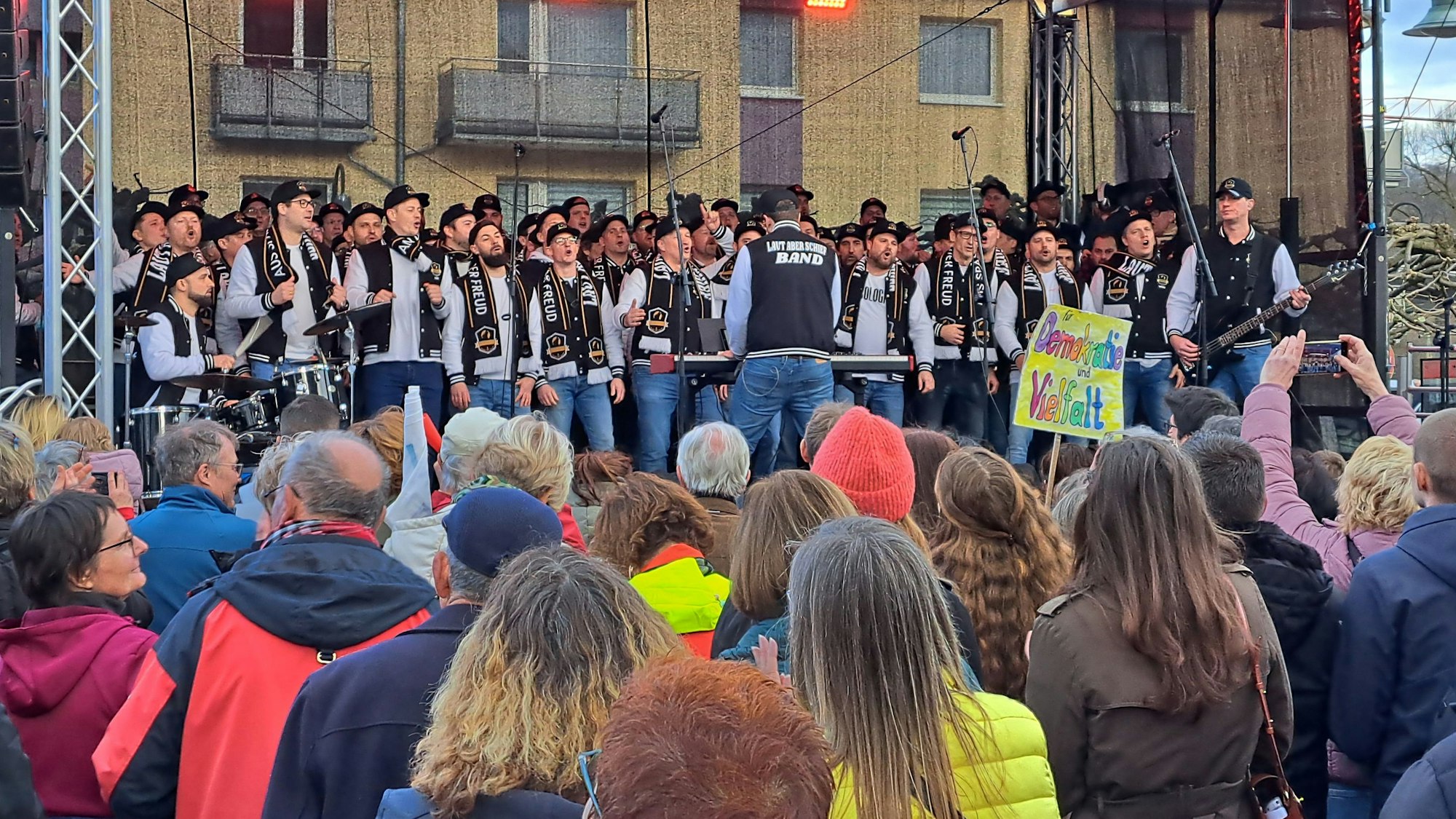Ein Chor steht auf einer Bühne am Overather Bahnhofplatz.