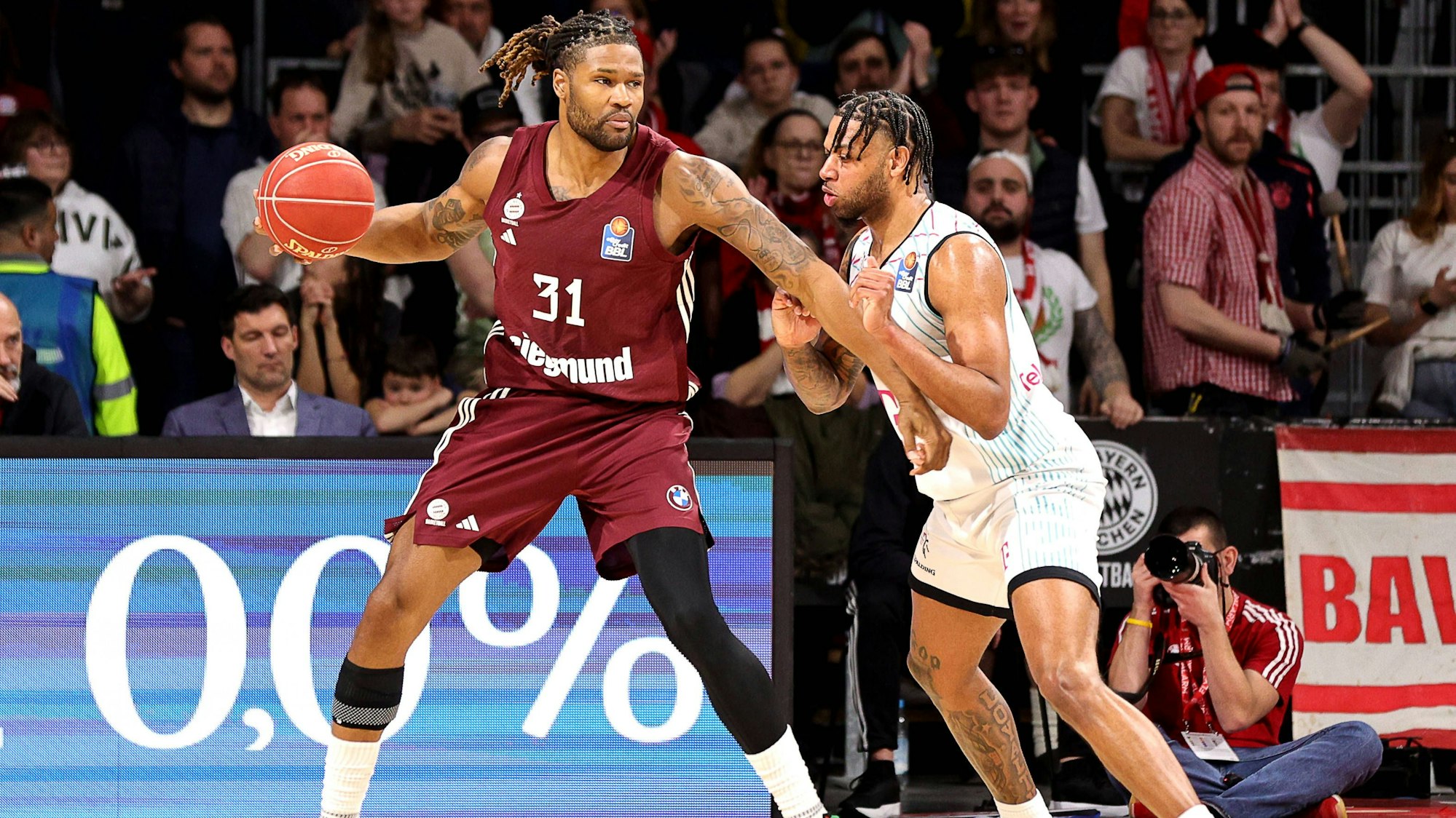 Baskets-Spieler Savion Flagg (r.) stemmt sich gegen Münchens Center Devin Booker.